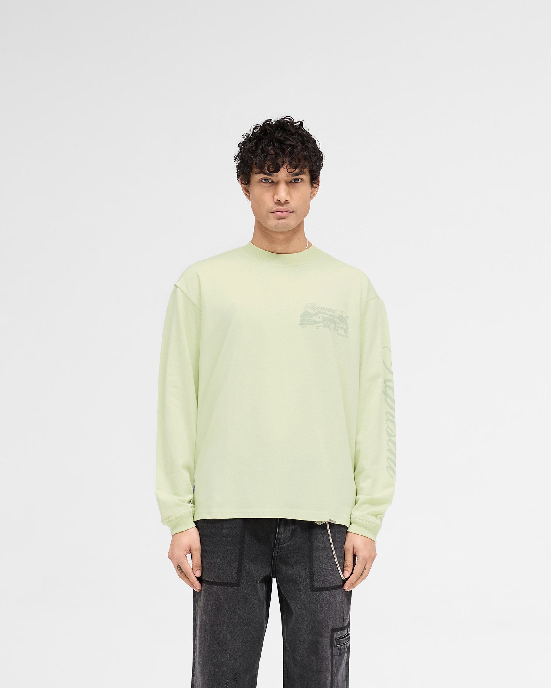 Man wearing a matcha long sleeve t-shirt on a plain white background | Raceway Long Sleeve T-Shirt in Matcha | Slightly oversized t-shirt with puff print graphics | SS25 T-Shirts | Represent Clo