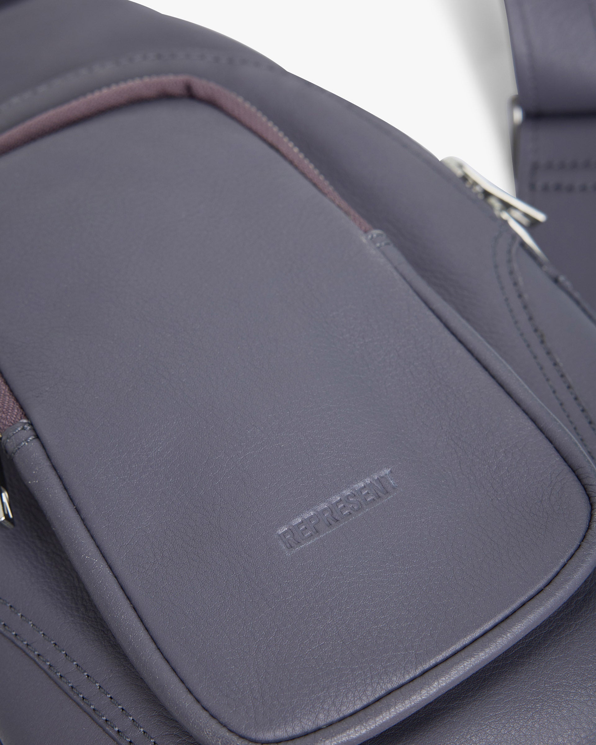 Back product image of a womens grey sling bag on a plain white background | Utility Sling Bag in Excalibur | Soft full grain leather sling bag with adjustable strap | SS25 Accessories | Represent Clo