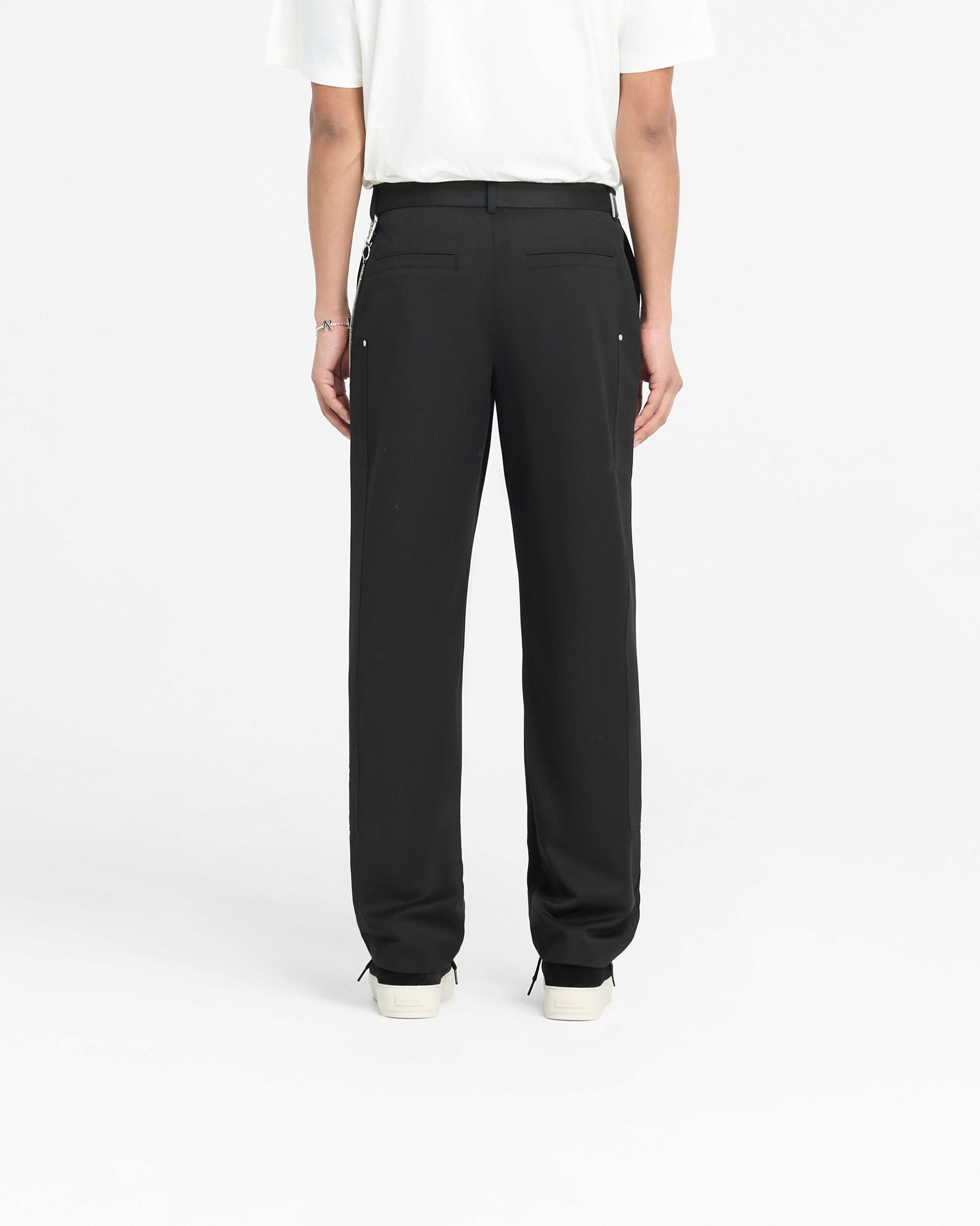 Man wearing black straight leg pants on a plain white background | Smart Utility Pant in Jet Black | Heavy fabric straight leg pants with pockets | PRE SS25 Pants | Represent Clo