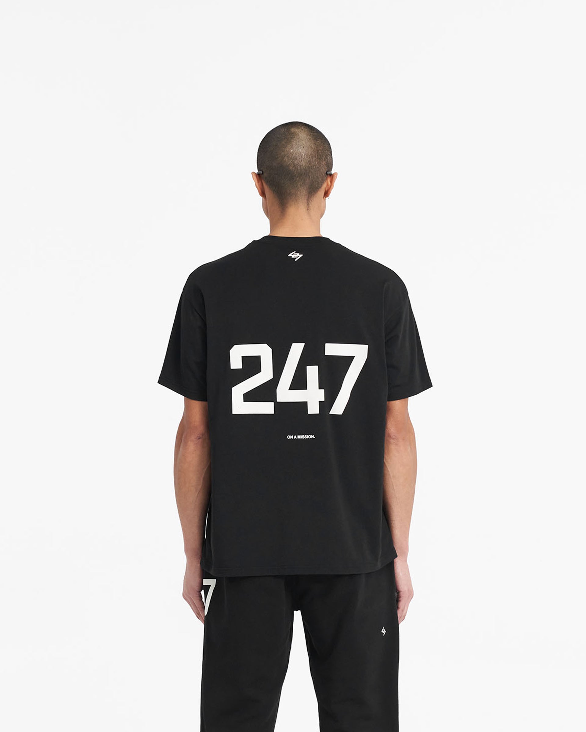 Man wearing an oversized black t-shirt on a plain white background | 247 Oversized T-Shirt in Jet Black | Oversized gym top with breathable antibacterial fabric | 247 T-Shirts | Represent Clo