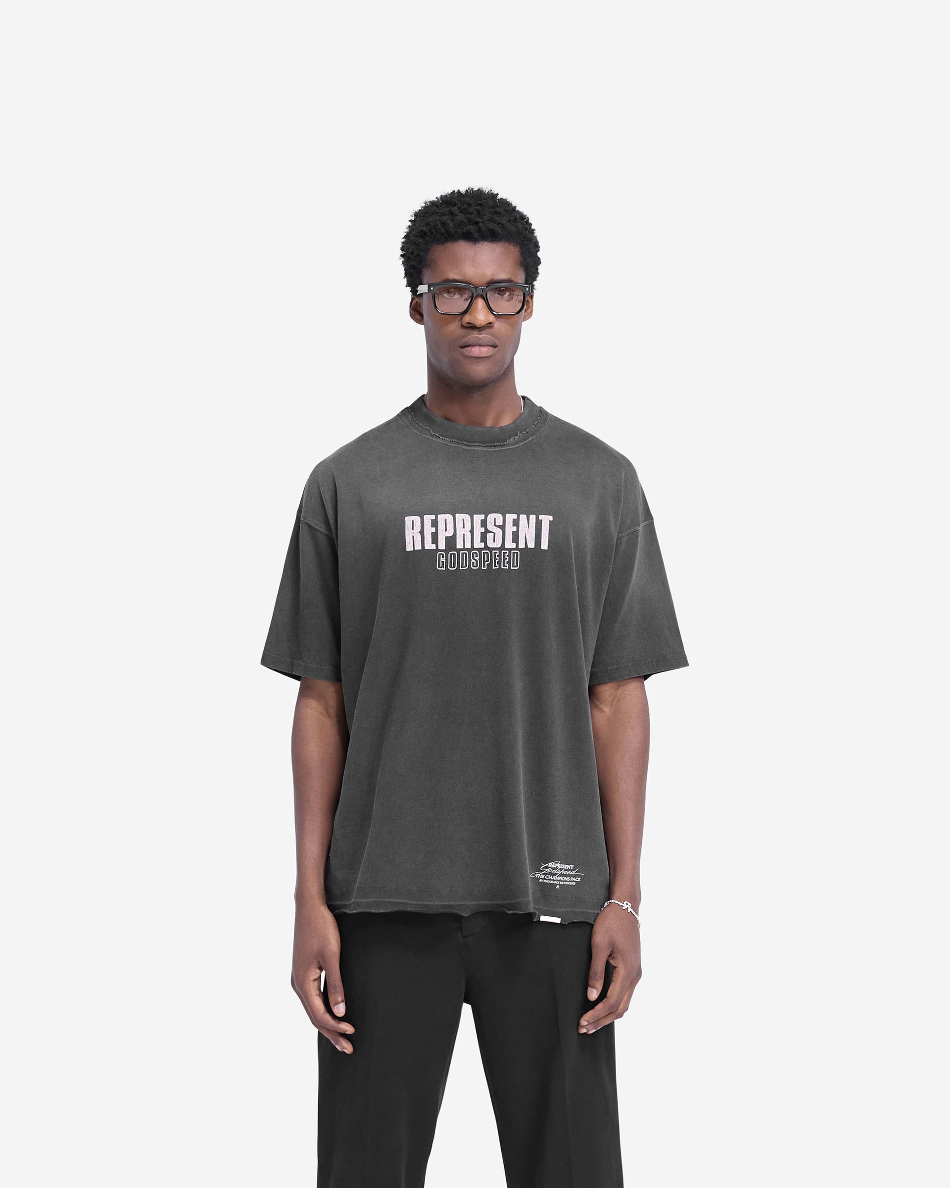Man wearing an aged black t-shirt on a plain white background | Godspeed T-Shirt in Aged Black | Oversized t-shirt with cracked graphic and raw hem | FW24 T-Shirts | Represent Clo