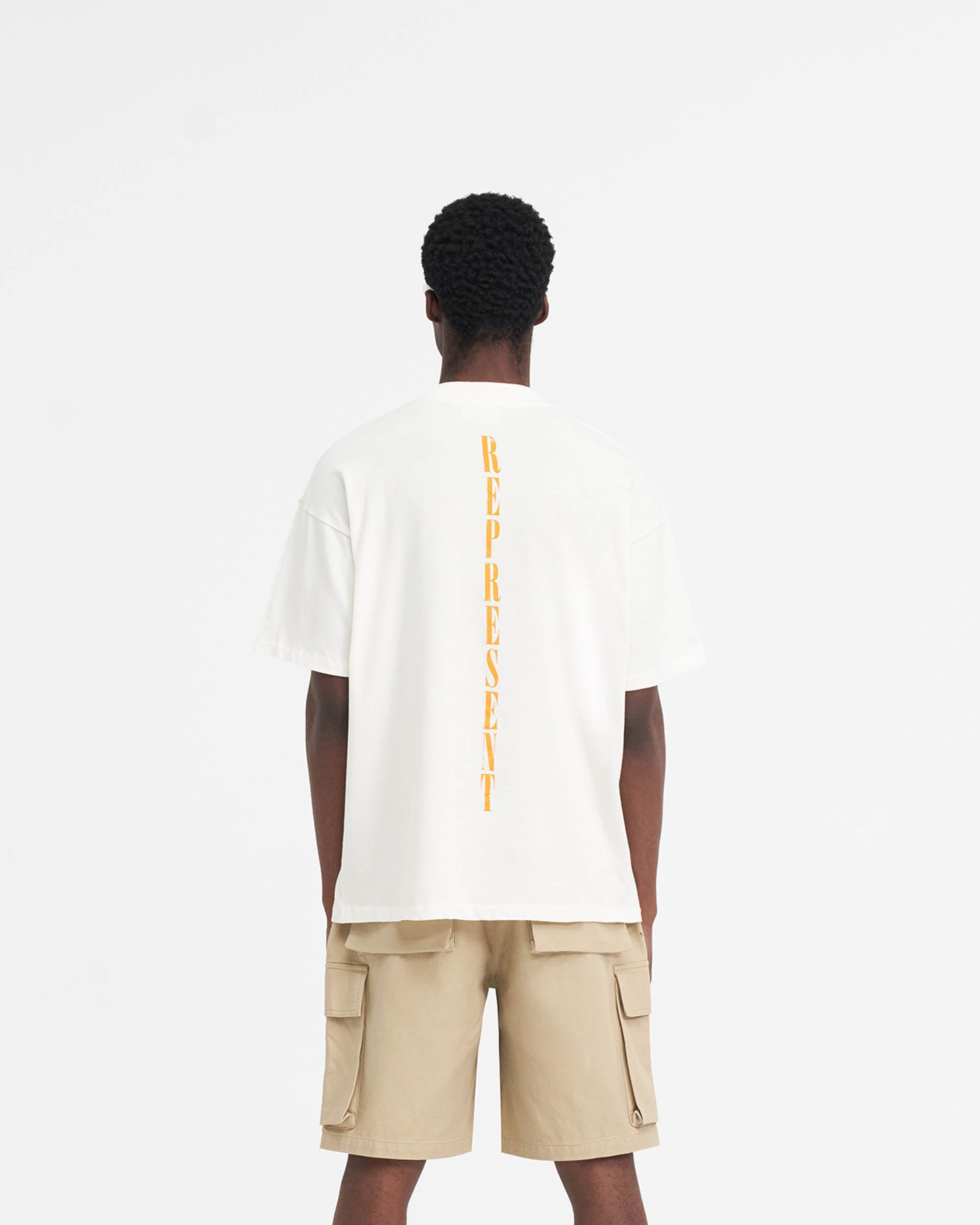 Man wearing a white t-shirt on a plain white background | Reborn T-Shirt in Flat White | Oversized t-shirt with Reborn graphic | SS24 T-Shirts | Represent Clo