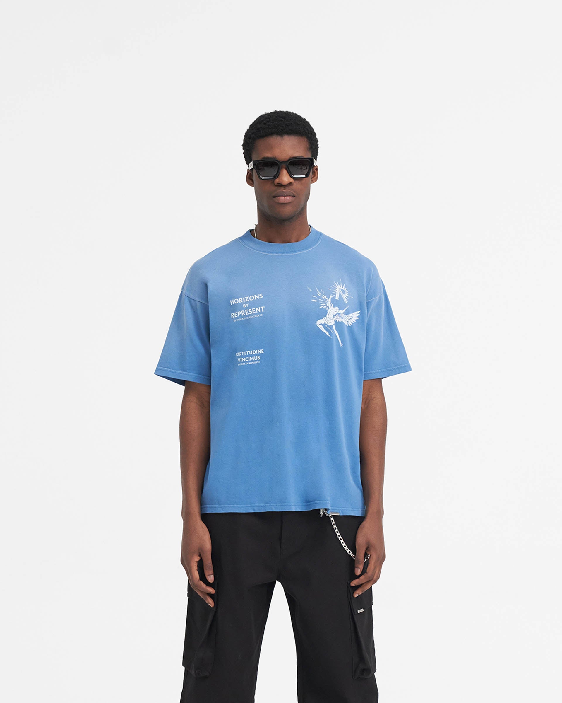 Man wearing a blue t-shirt on a plain white background | Icarus T-Shirt in Sky Blue | T-Shirt with Icarus graphic and oversized fit | SS24 T-Shirts | Represent Clo