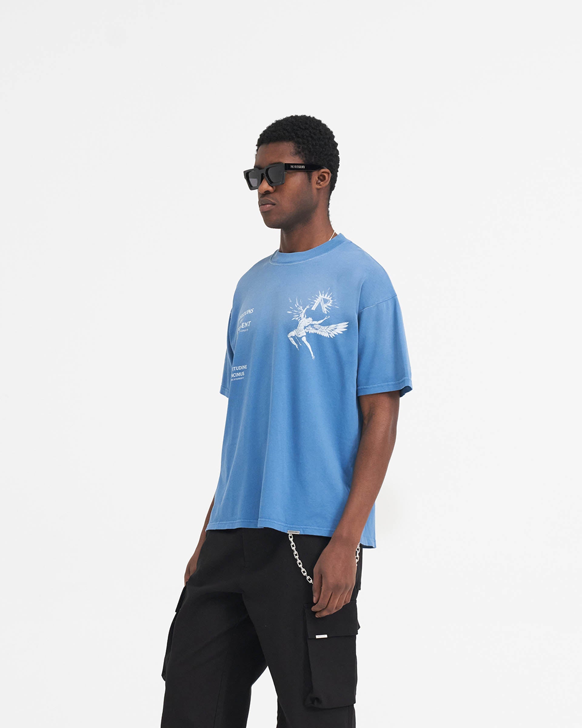 Man wearing a sky blue t-shirt on a plain white background | Icarus T-Shirt in Sky Blue | Slightly oversized t-shirt with Icarus graphic | SS24 T-Shirts | Represent Clo