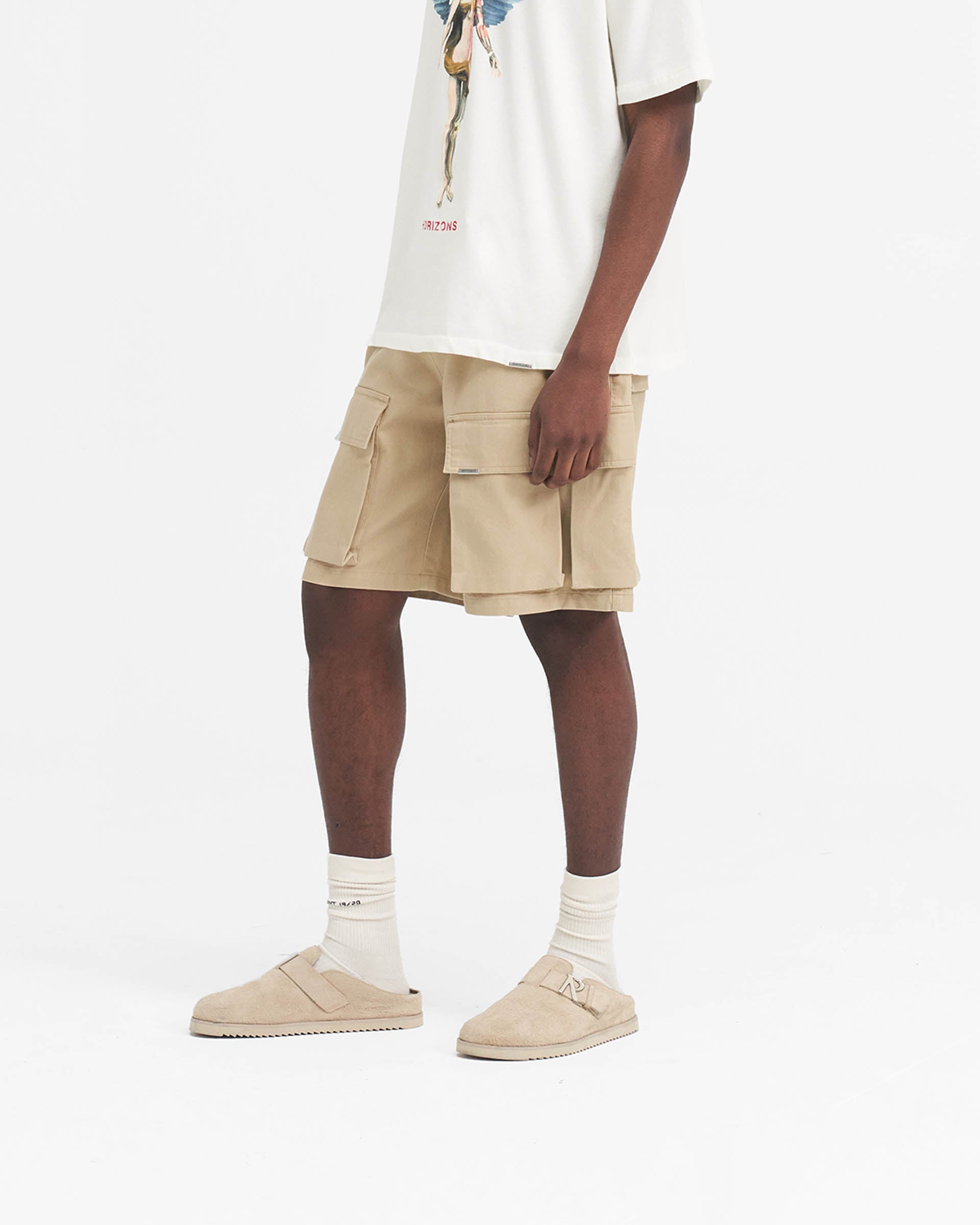 Back product image of a mens beige cotton cargo short on a plain white background | Baggy Cotton Cargo Short in Sandstone | Cargo shorts with baggy fit and oversized 3D pockets | SS24 Shorts | Represent Clo