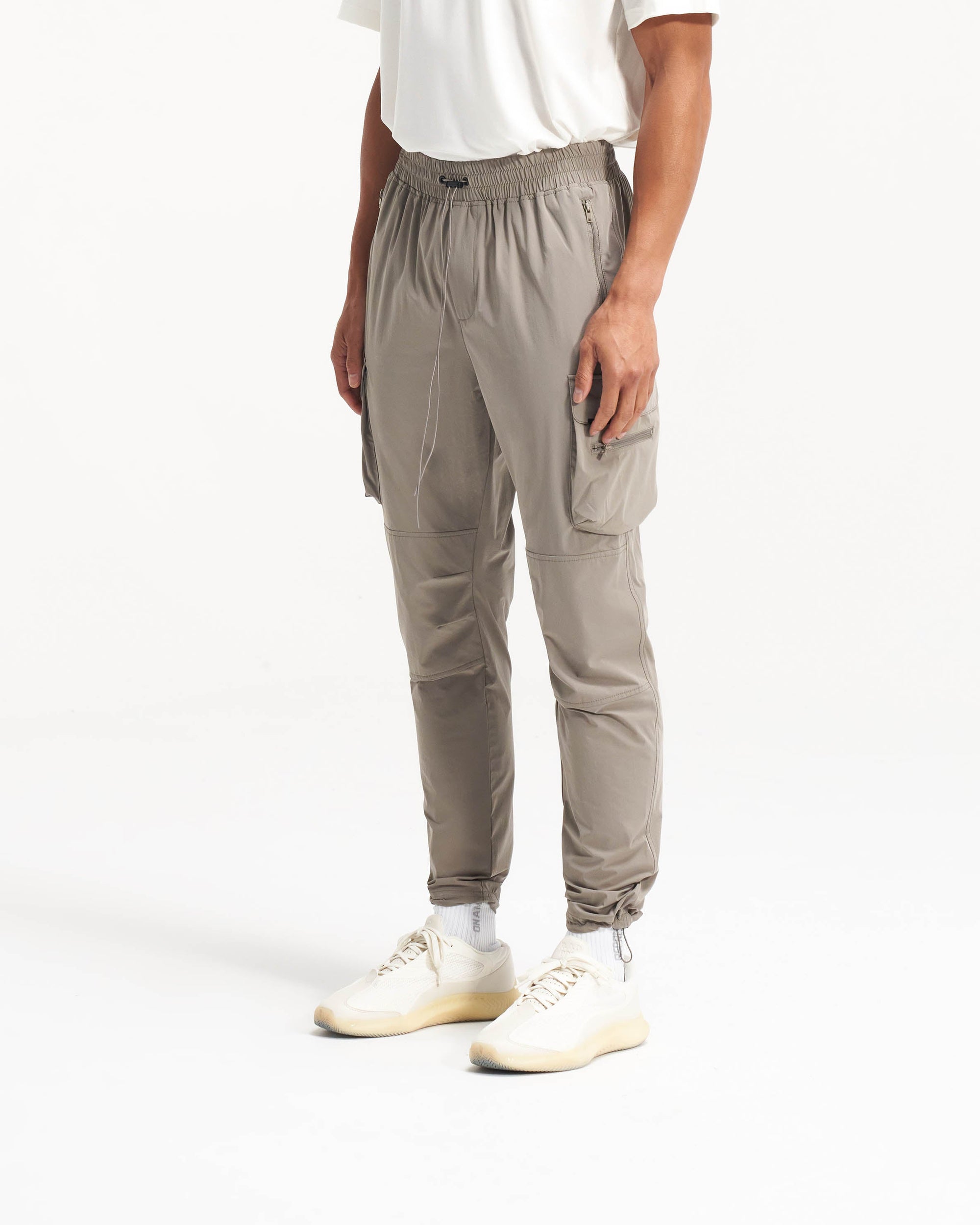 Back product image of mens taupe pants on a plain white background | 247 Pant in Taupe | Cargo pants with technical 4-way stretch and cargo pockets | 247 Pants | Represent Clo
