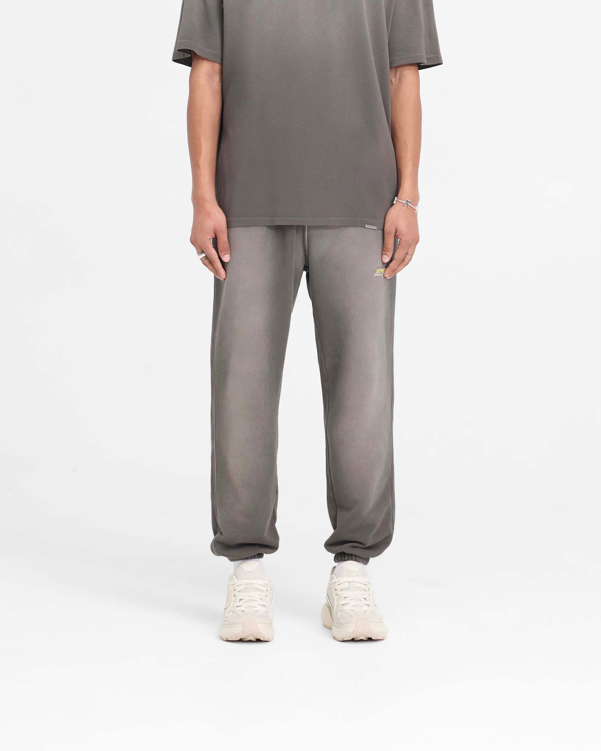 Man wearing washed olive sweatpants on a plain white background | Patron Of The Club Sweatpant in Washed Olive | Heavy weight cotton sweatpants with elasticated waistband | Patrons Pants | Represent Clo