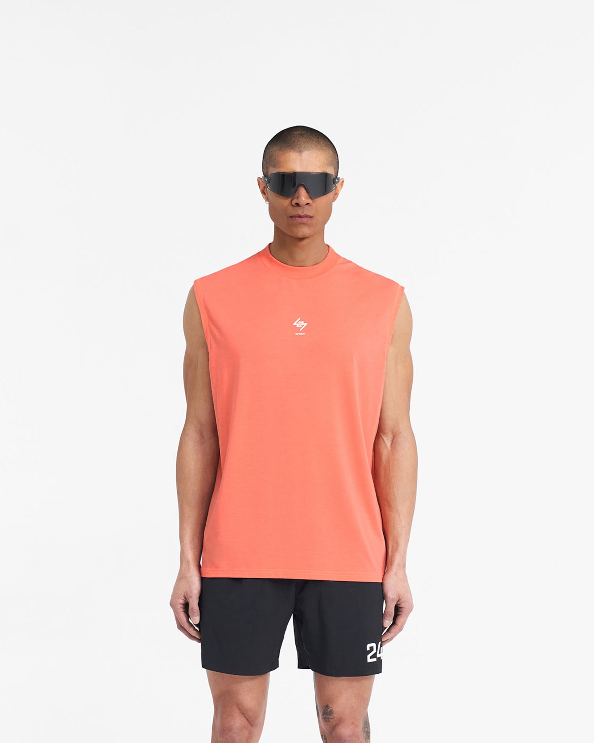 Man wearing a coral tank top on a plain white background | 247 Oversized Tank in Coral | Technical tank with breathable fabric and 247 branding | 247 T-Shirts | Represent Clo