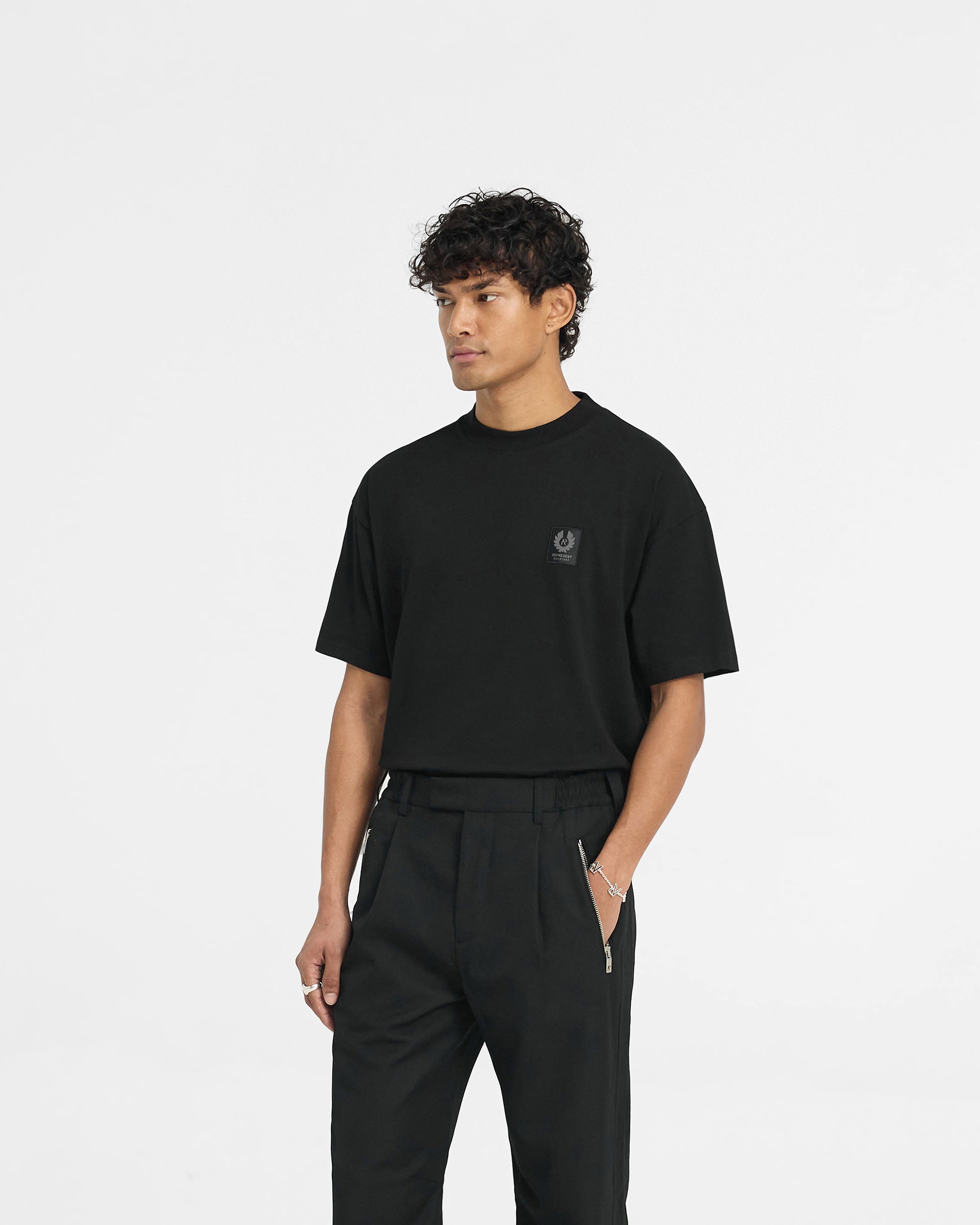 Back product image of a mens black t-shirt on a plain white background | Represent X Belstaff Patch T-Shirt in Black | Oversized t-shirt with woven patch branding | Exclusives T-Shirts | Represent Clo