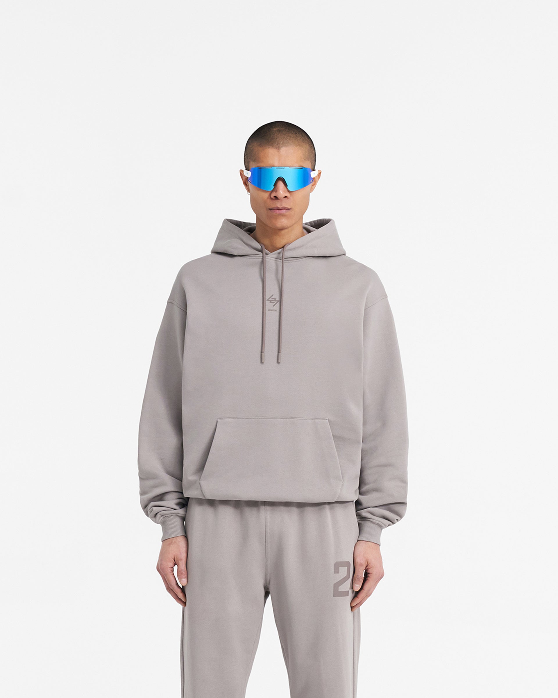 Man wearing an oversized grey hoodie on a plain white background | 247 Oversized Hoodie in Cinder | Hoodie with ribbed cuffs and hem | 247 Hoodies | Represent Clo