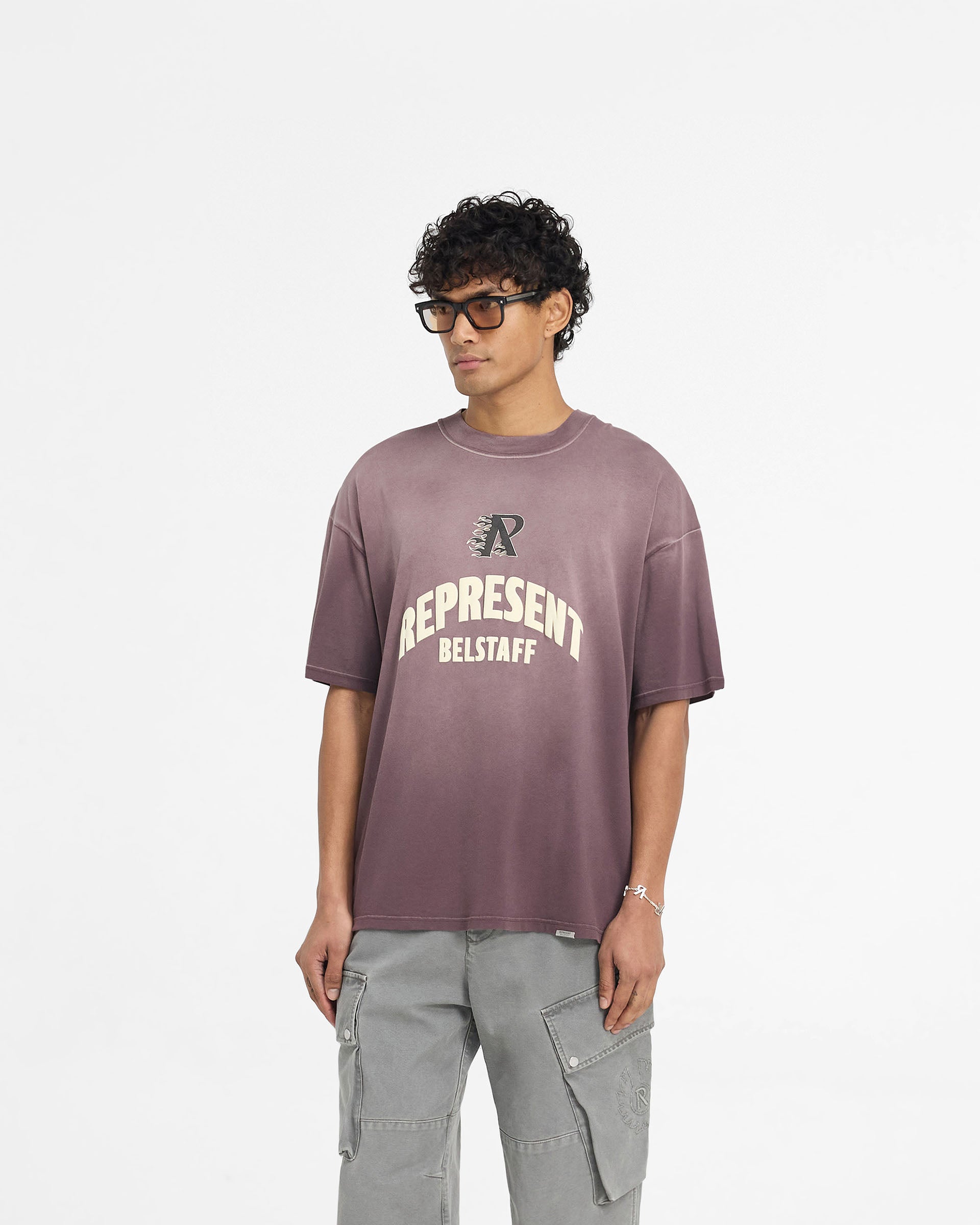 Man wearing a plum t-shirt on a plain white background | Represent X Belstaff Flame Phoenix T-Shirt in Plum | Oversized t-shirt with Initial & Phoenix logos | Exclusives T-Shirts | Represent Clo