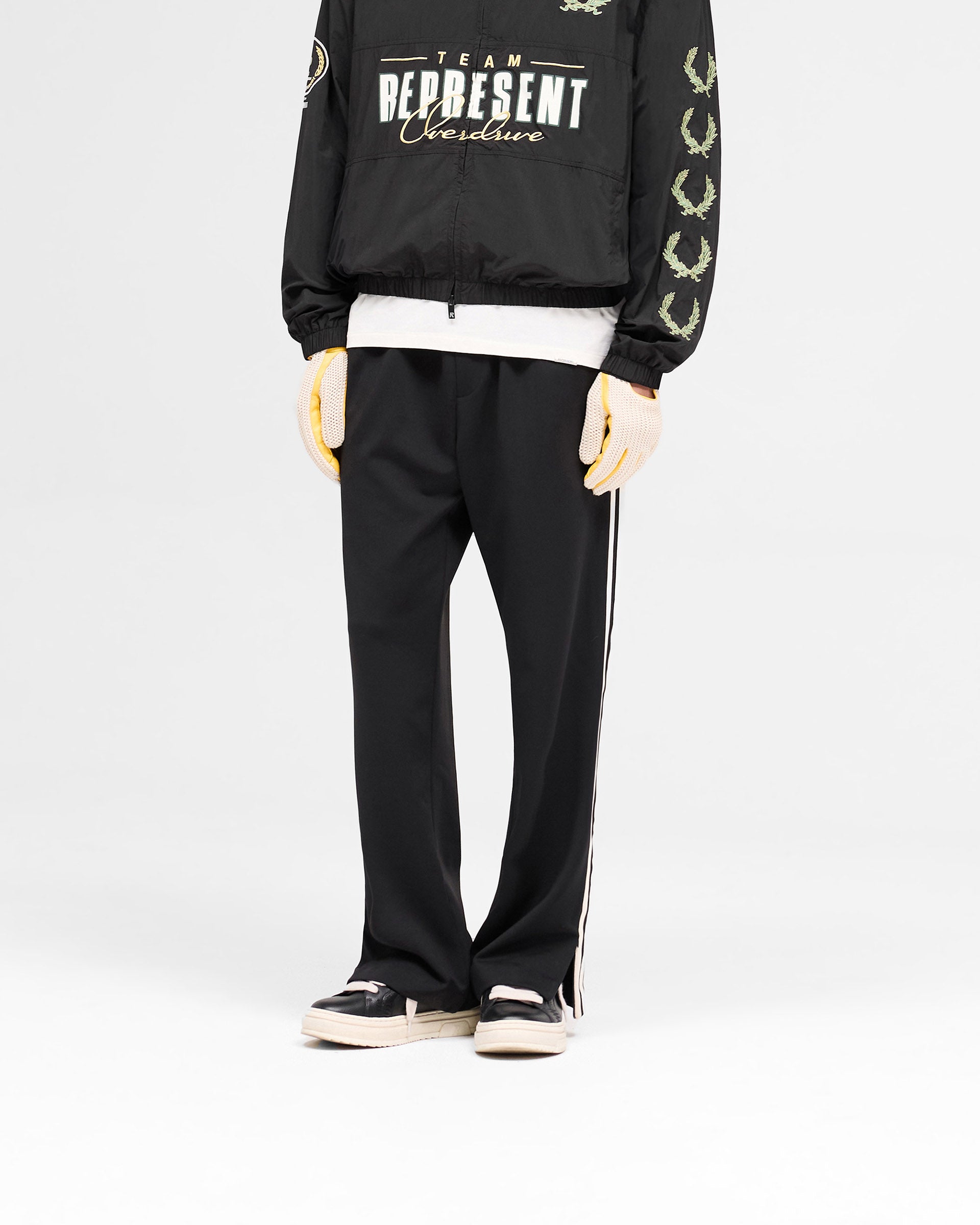 Back product image of mens black pants on a plain white background | Tailored Track Pant in Jet Black | Pants with elasticated waistband and zip details | SS25 Pants | Represent Clo