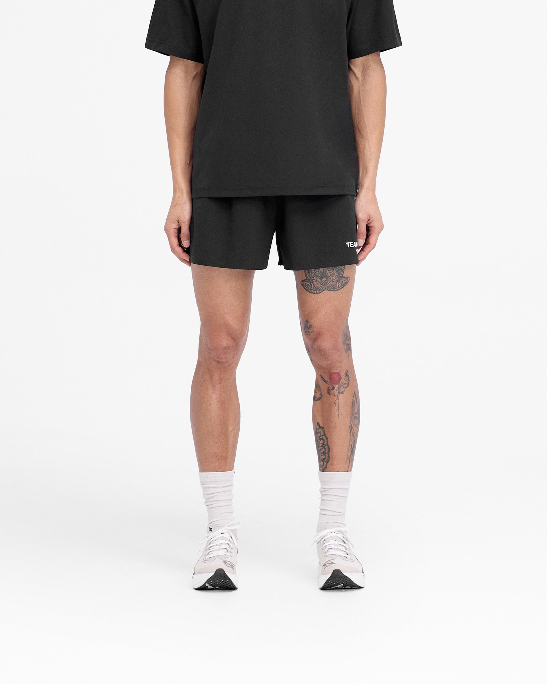 Man wearing black shorts on a plain white background | 247 X Puma Shorts in Black | Lightweight ultraweave shorts with mesh waistband | 247 Shorts | Represent Clo