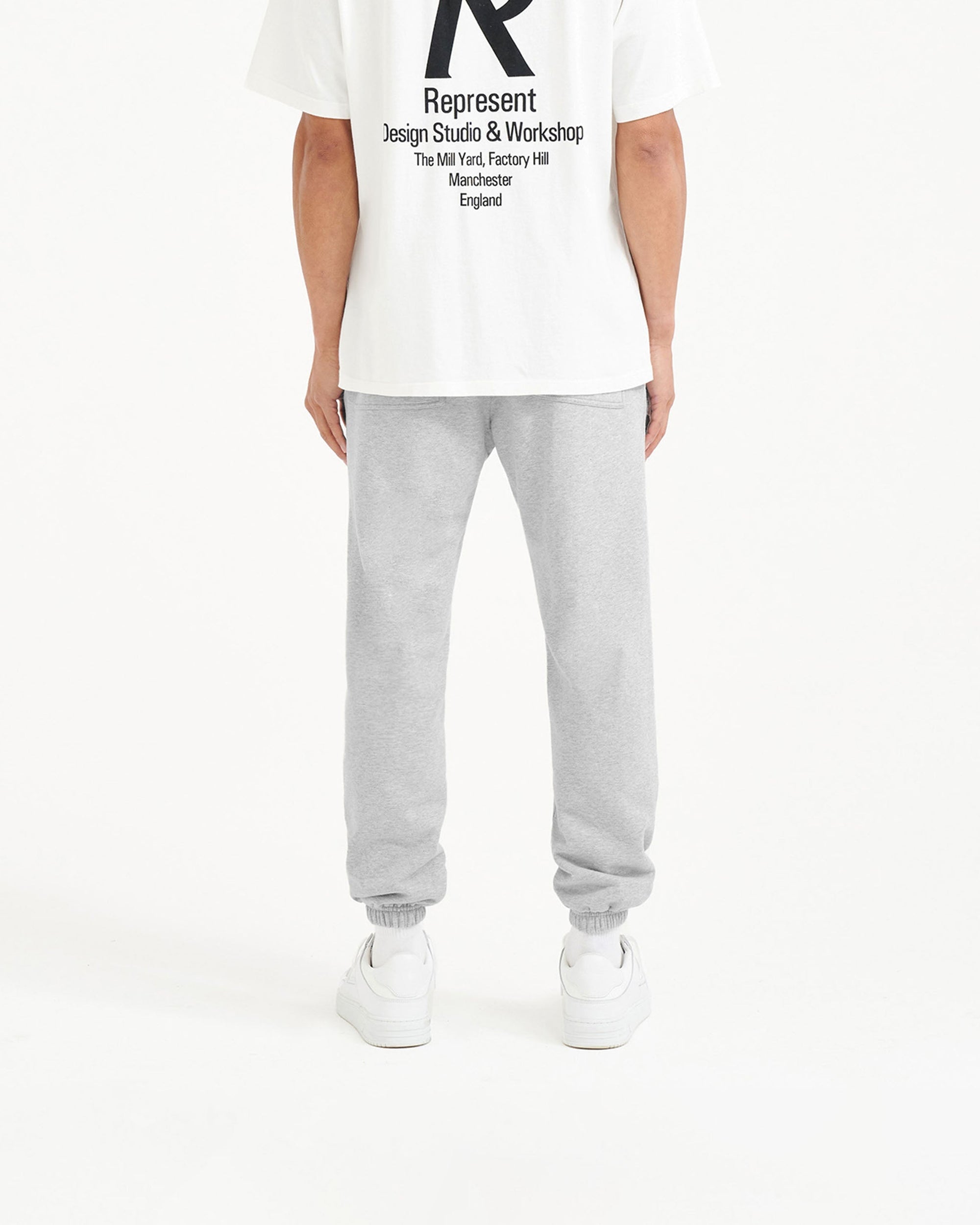 Man wearing grey sweatpants on a plain white background | Represent Owners Club Sweatpant in Ash Grey | Sweatpants with elasticated waistband and cuffs | Owners Club Pants | Represent Clo