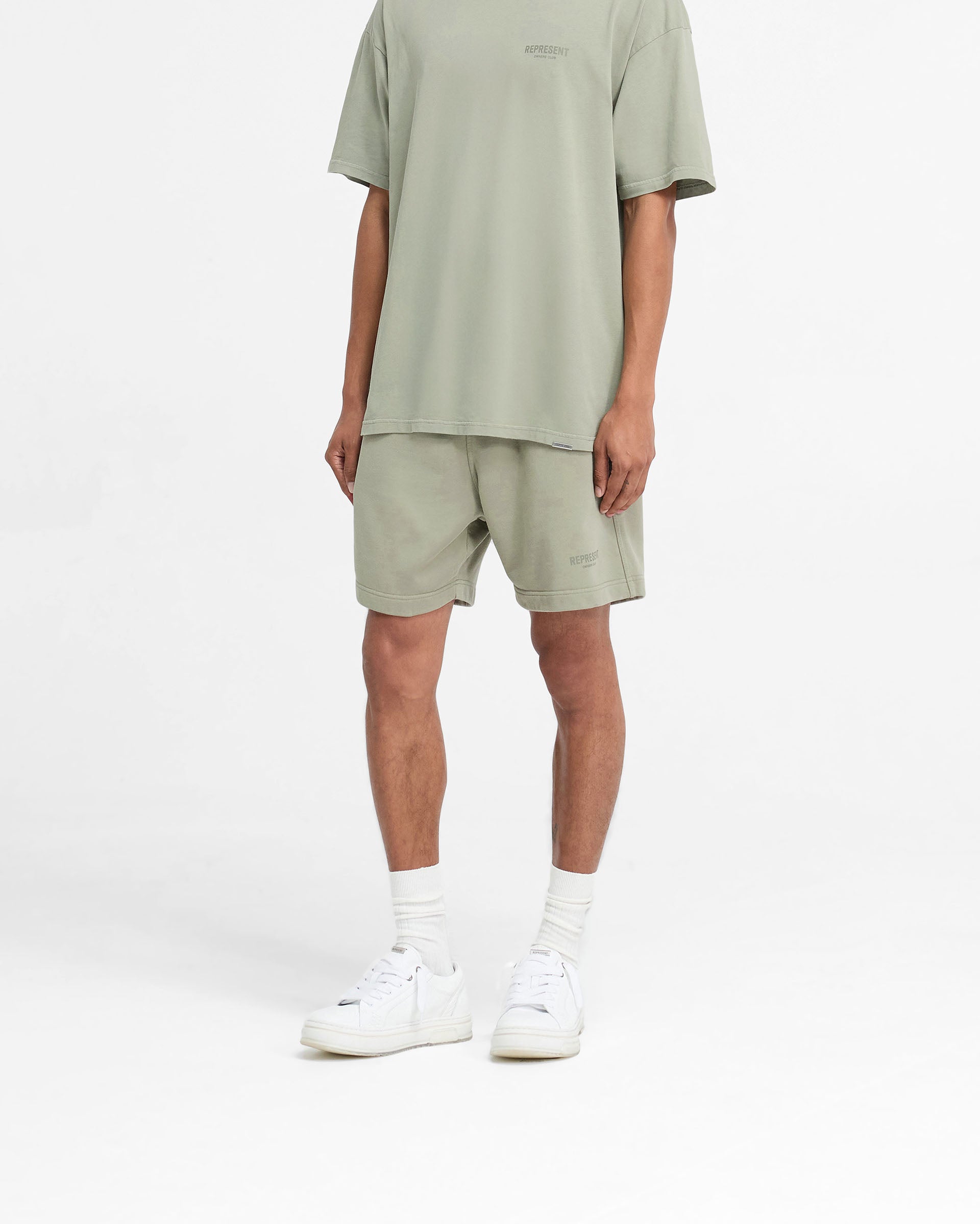 Back product image of mens green shorts on a plain white background | Represent Owners Club Shorts in Pastel Green | Shorts with elasticated waistband and pockets | Owners Club Shorts | Represent Clo