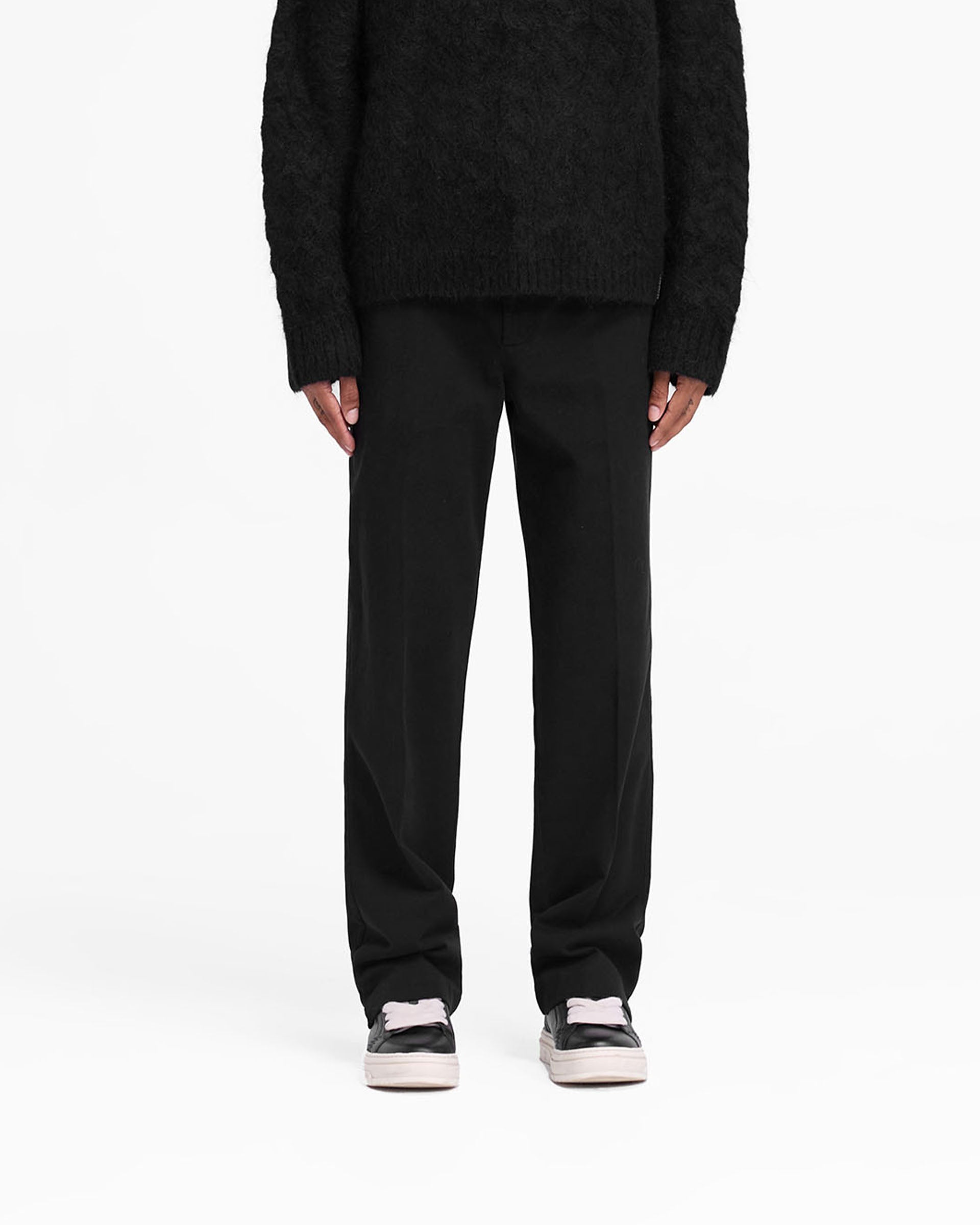 Man wearing black cotton pants on a plain white background | Cotton Pant in Black | Straight leg cotton twill pants with side split | FW24 Pants | Represent Clo