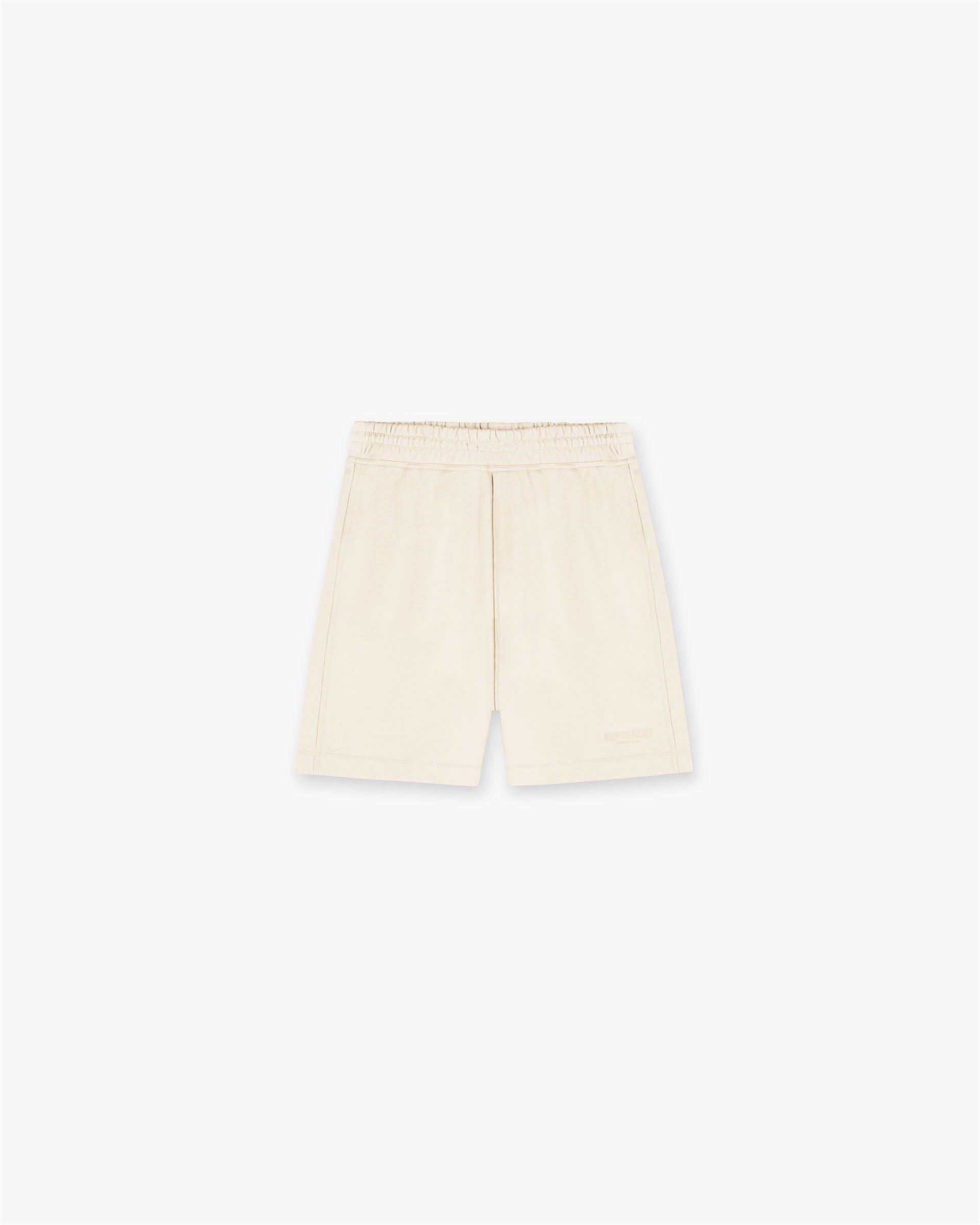 Front product image of a mens cream shorts on a plain white background | Represent Owners Club Shorts in Buttercream | Relaxed fit shorts with elasticated waist | Owners Club Shorts | Represent Clo