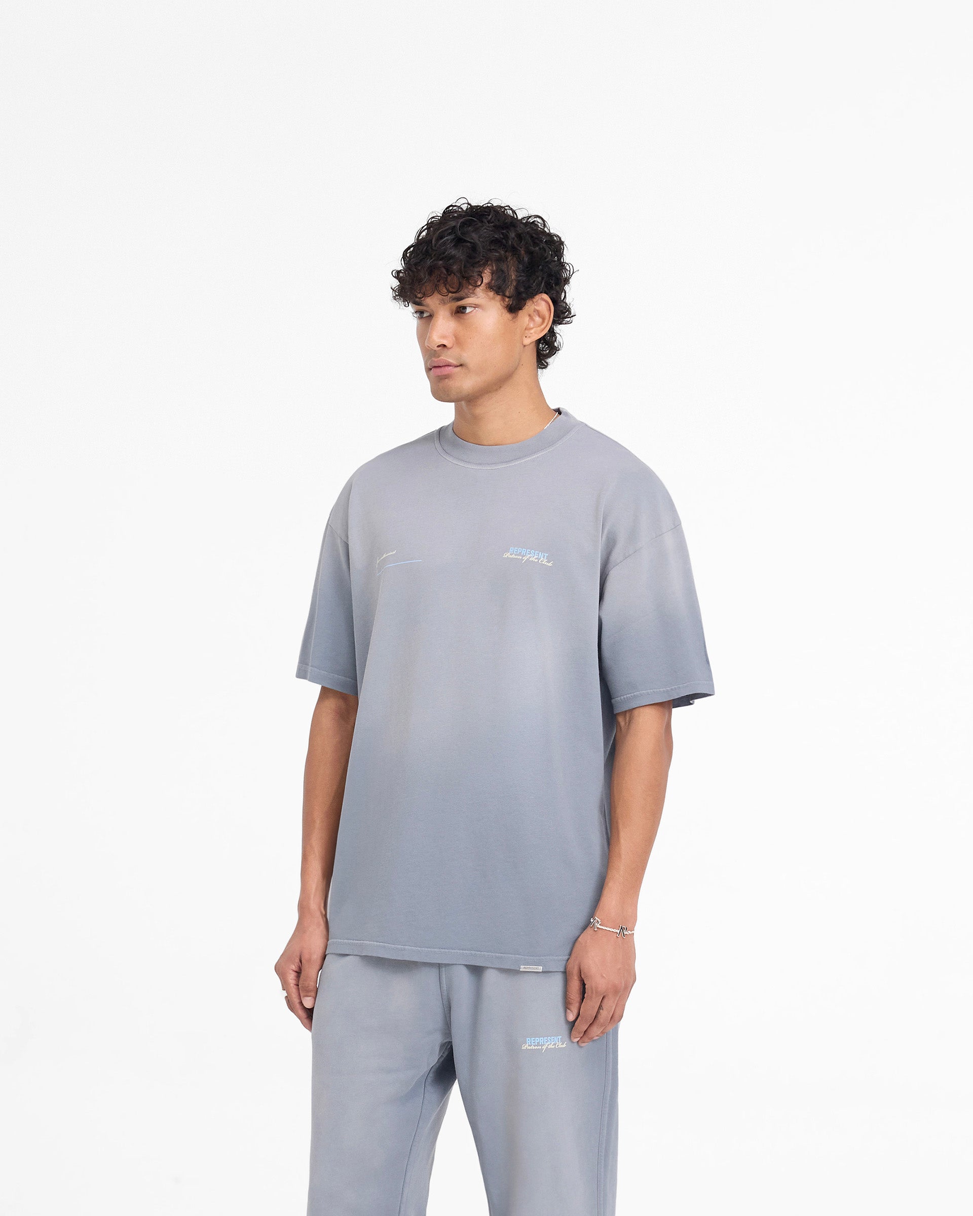Man wearing a grey t-shirt on a plain white background | Patron Of The Club T-Shirt in Washed Grey | Slightly oversized t-shirt with fade out wash | Patrons T-Shirts | Represent Clo