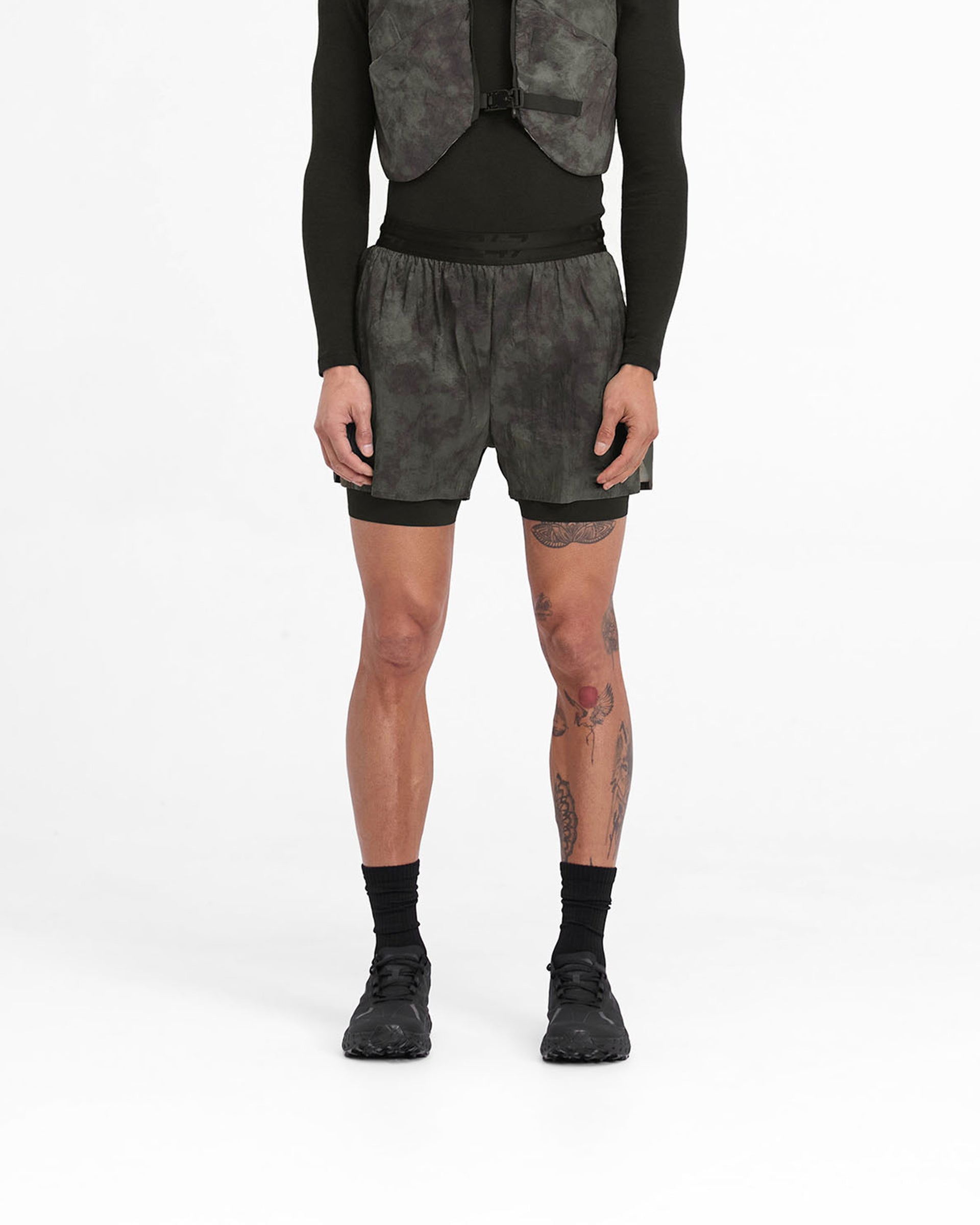 Man wearing grey trail shorts on a plain white background | 247 Trail Short in Terrain | Shorts with 2-in-1 design and 247 branding | 247 Shorts | Represent Clo