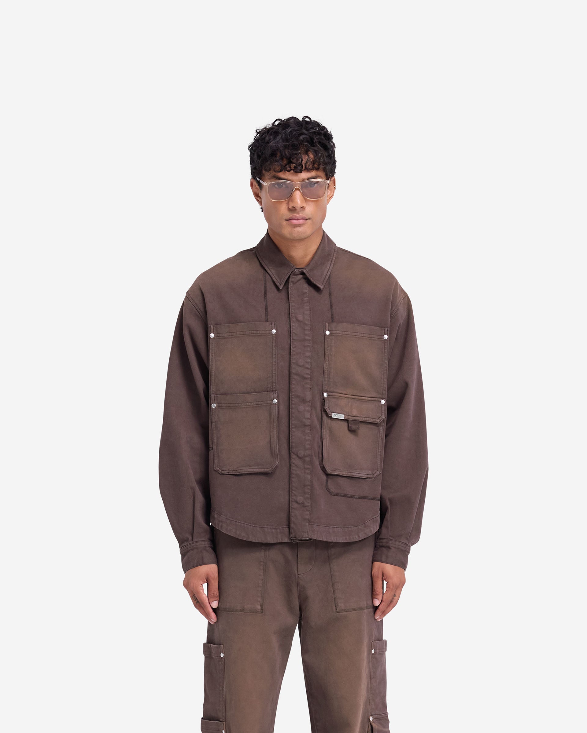 Man wearing a cedar overshirt on a plain white background | Workshop Shirt in Cedar | Everyday overshirt with concealed popper closures | FW24 Shirts | Represent Clo