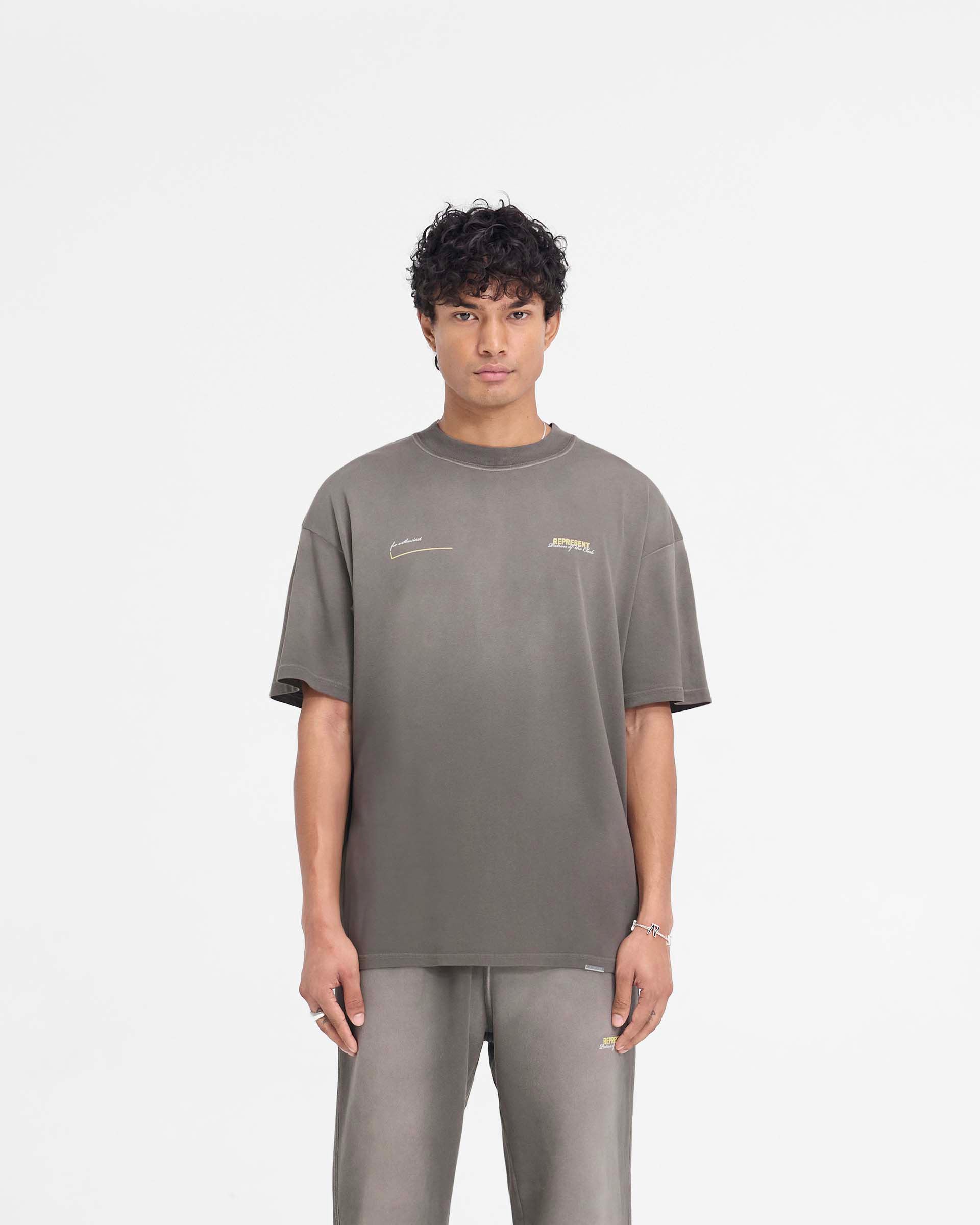 Man wearing a washed olive t-shirt on a plain white background | Patron Of The Club T-Shirt in Washed Olive | Slightly oversized fit t-shirt with fade out wash | Patrons T-Shirts | Represent Clo