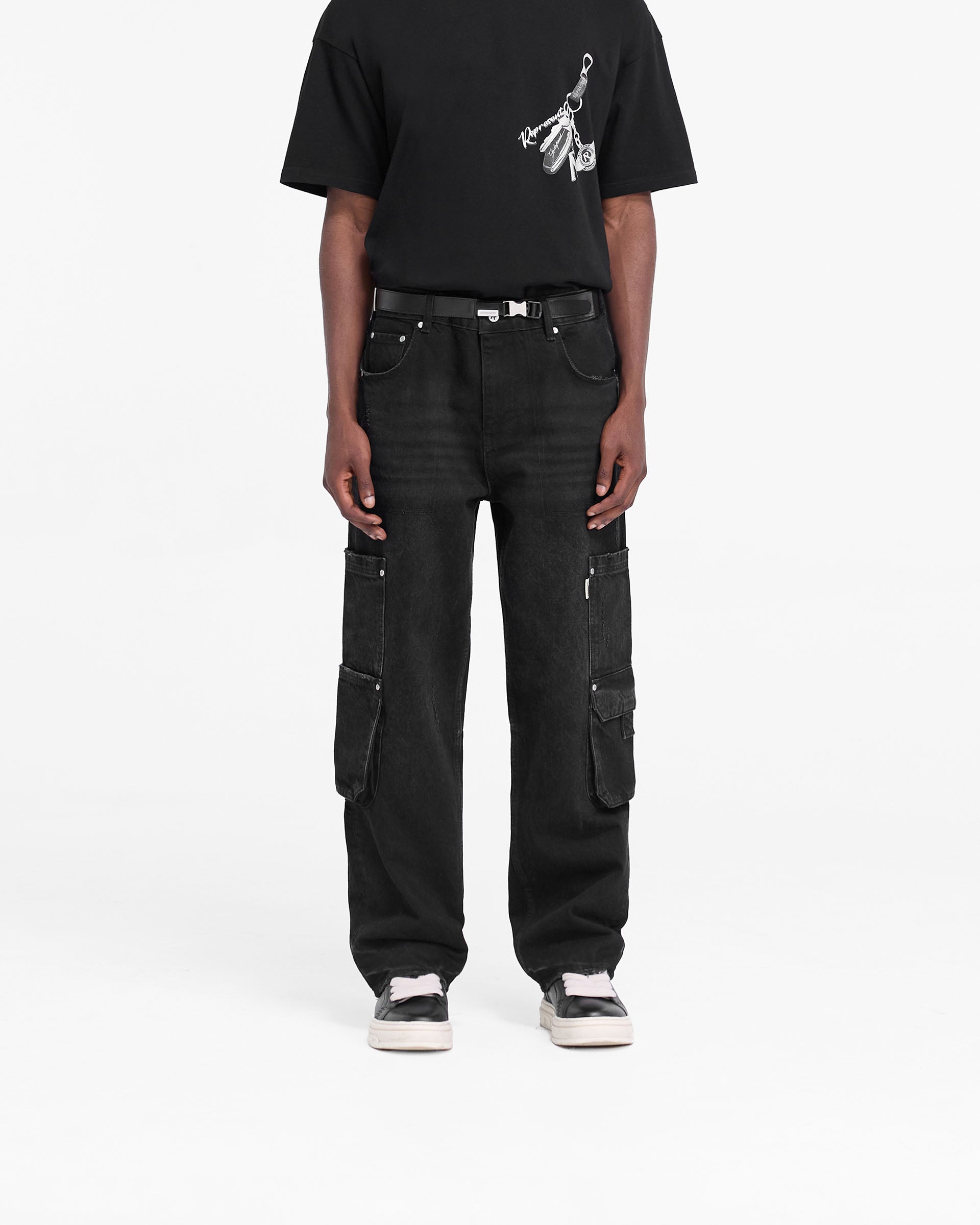 Man wearing black denim jeans on a plain white background | R3 Workshop Denim in Black | Baggy fit jeans with double leg pockets | FW24 Denim | Represent Clo