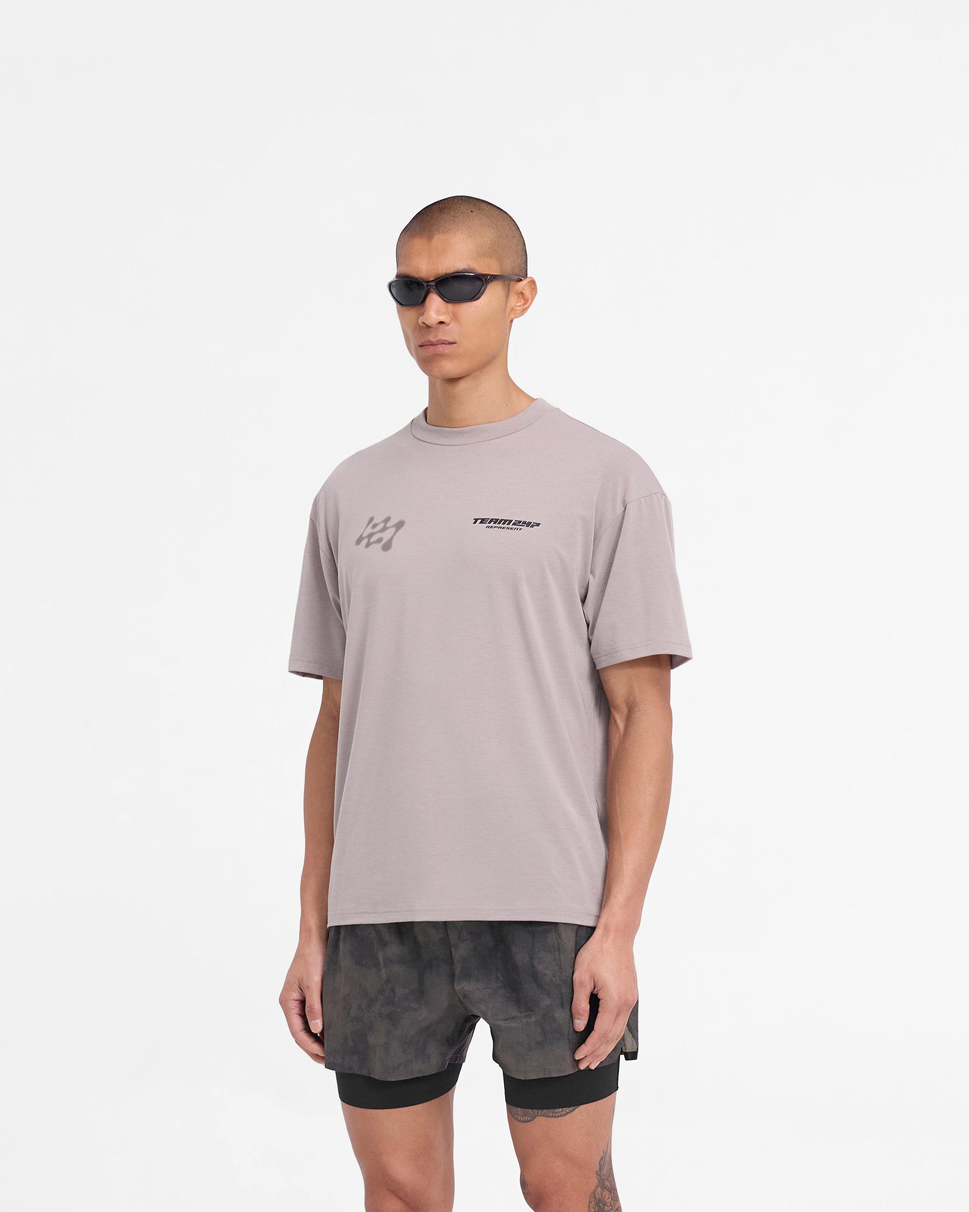 Man wearing an oversized grey t-shirt on a plain white background | 247 Future Terrains Oversized T-Shirt in Moonrock | Quick drying breathable oversized t-shirt | 247 T-Shirts | Represent Clo