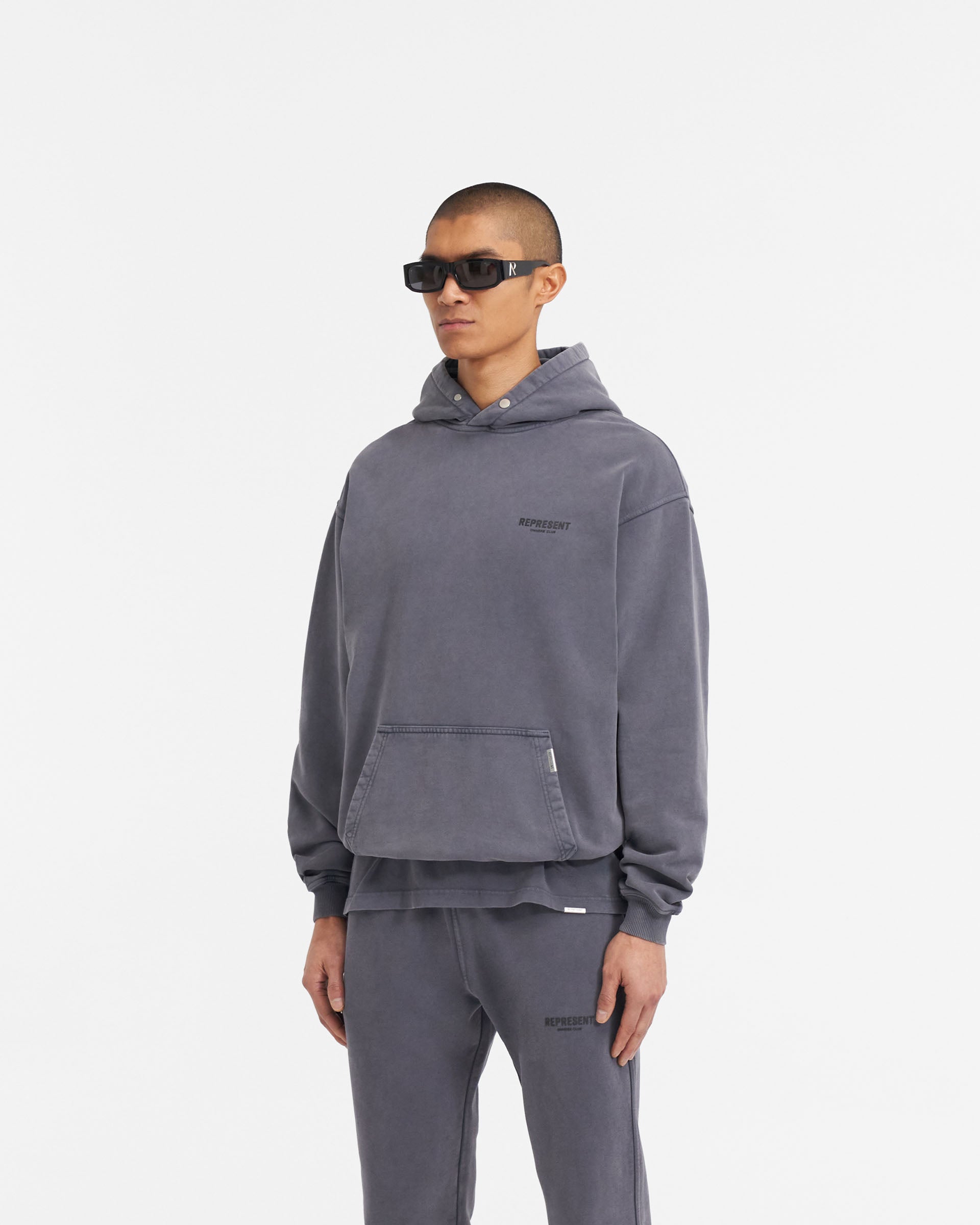 Man wearing an oversized grey hoodie on a plain white background | Represent Owners Club Hoodie in Storm | Heavy weight jersey hoodie with ribbed trims | Owners Club Hoodies | Represent Clo