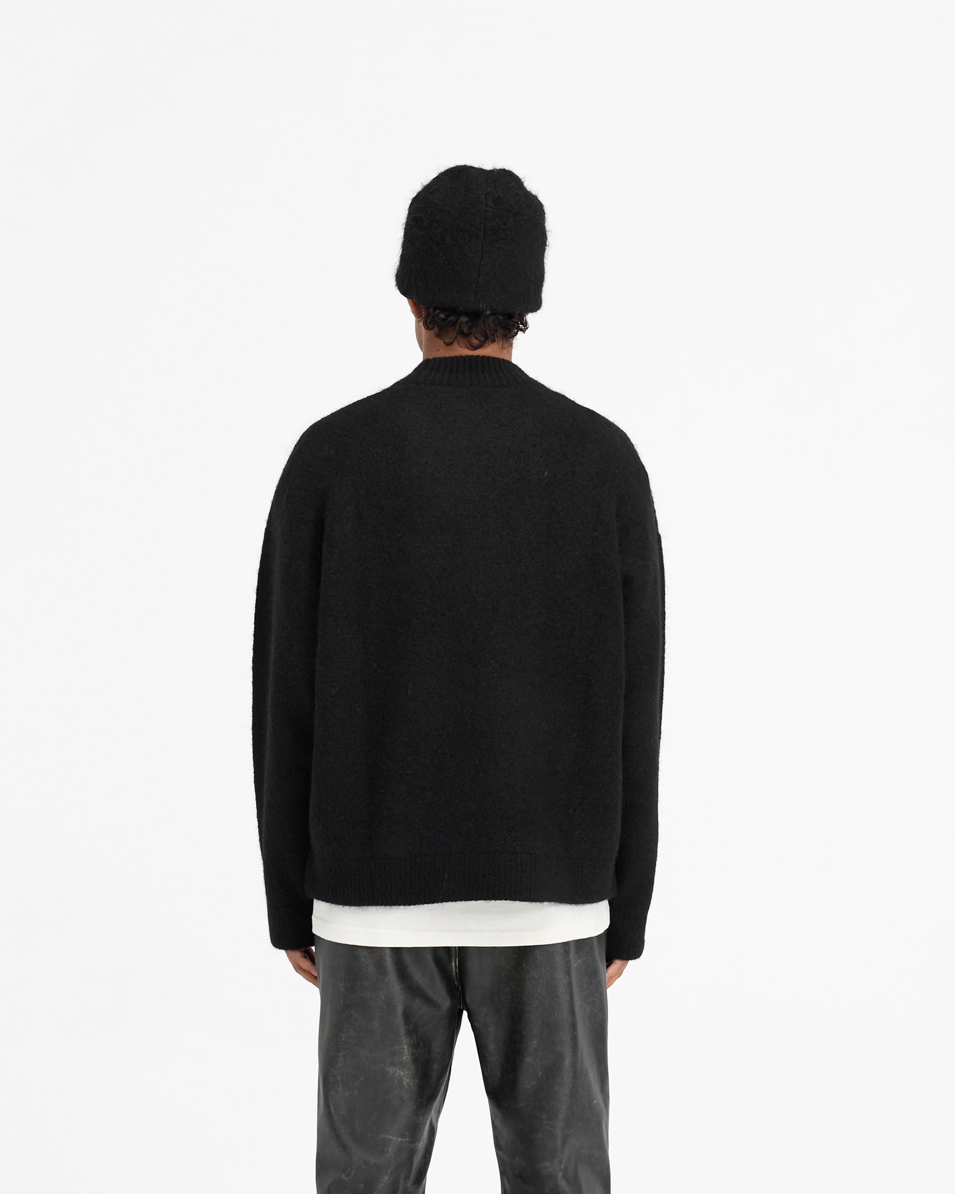 Man wearing an oversized black knit sweater on a plain white background | Alpaca Blend Sweater in Jet Black | Oversized alpaca knit jumper with ribbed detailing | FW24 Knitwear | Represent Clo