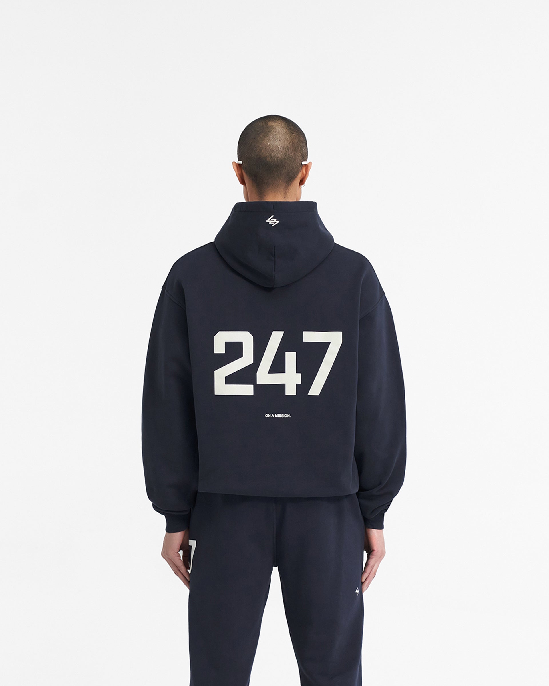 Man wearing an oversized navy hoodie on a plain white background | 247 Oversized Hoodie in Navy | Oversized hoodie with ribbed cuffs and hem | 247 Hoodies | Represent Clo