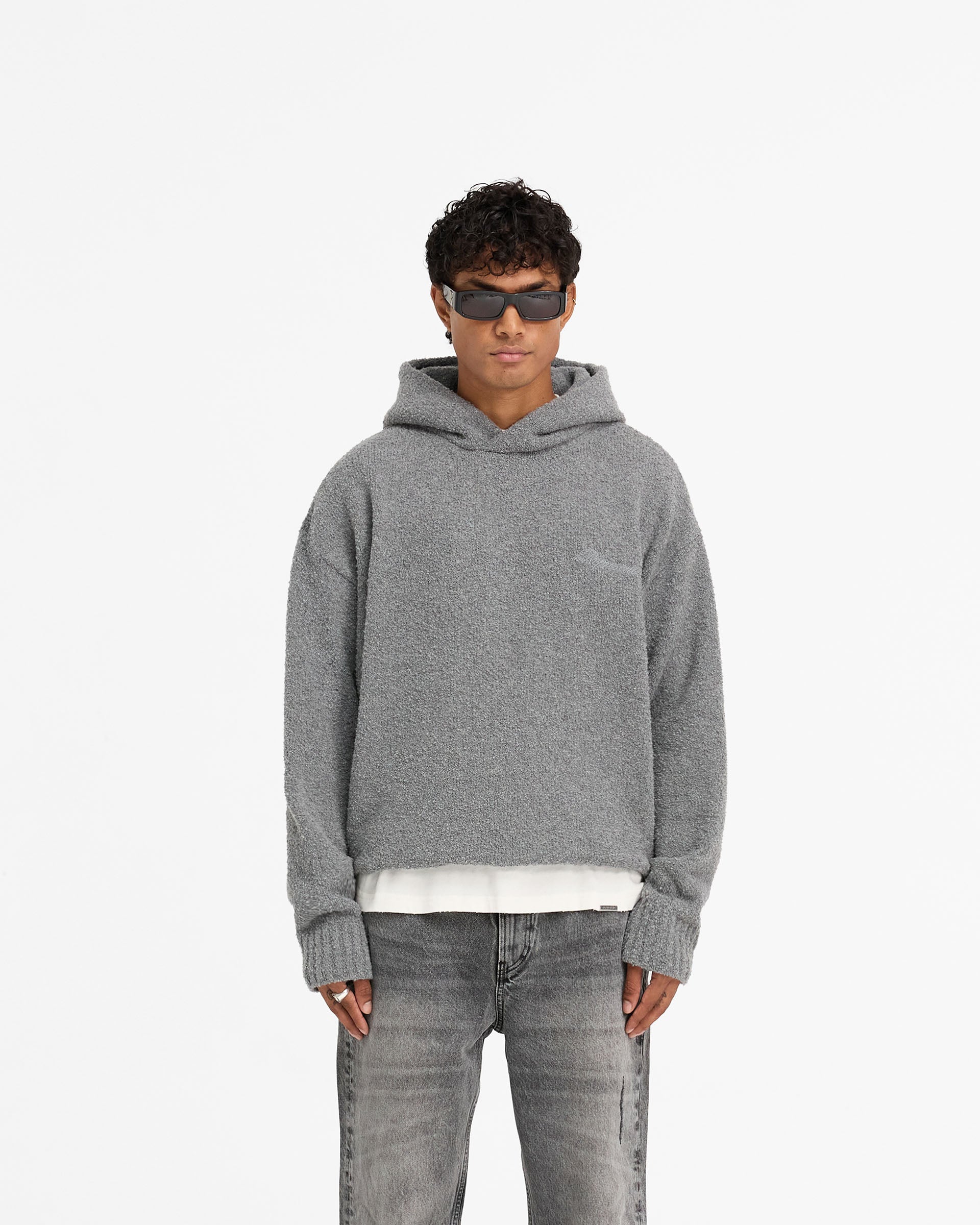 Man wearing an oversized grey hoodie on a plain white background | Heavy Boucle Hoodie in Rock | Double lined oversized boxy knit hoodie | FW24 Knitwear | Represent Clo
