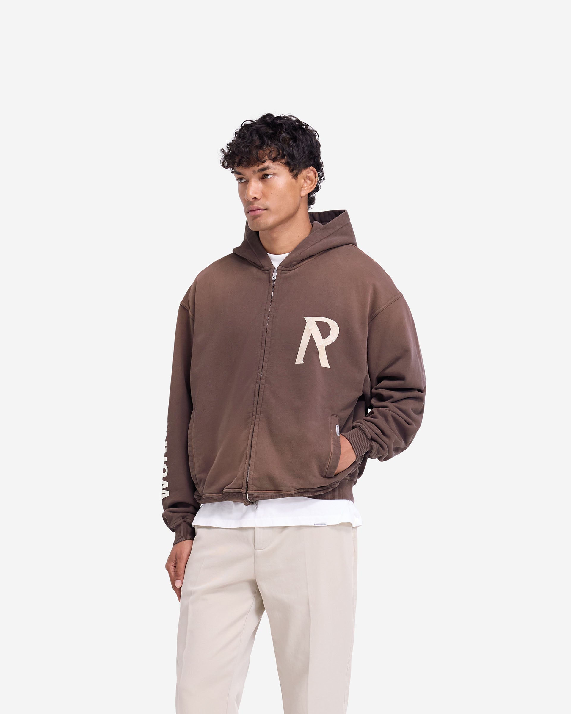 Man wearing a cedar zip hoodie on a plain white background | Masking Tape Initial Zip Hoodie in Cedar | Slightly oversized hoodie with double ended front zip | FW24 Hoodies | Represent Clo