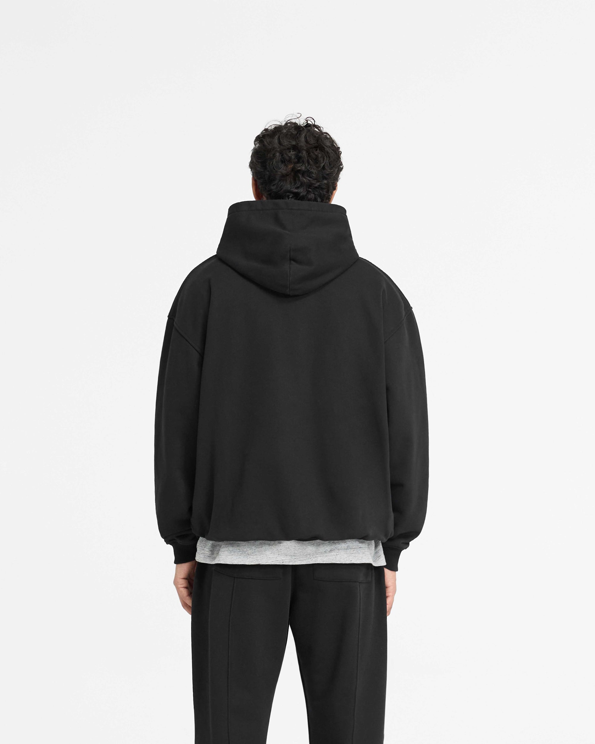 Man wearing a black hoodie on a plain white background | England Applique Hoodie in Jet Black | Oversized hoodie with applique embroidery | PRE SS25 Hoodies | Represent Clo