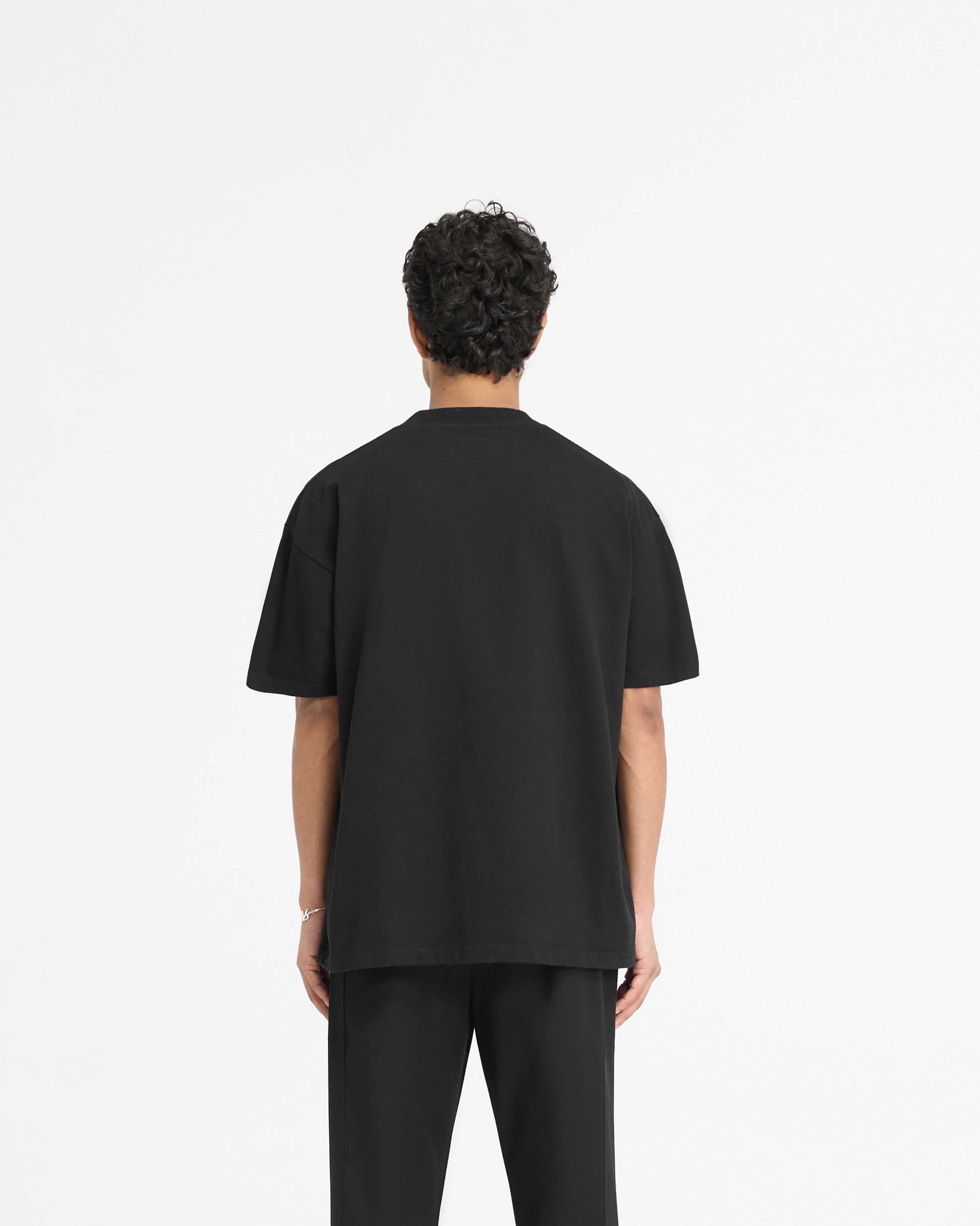 Man wearing a black t-shirt on a plain white background | England Applique T-Shirt in Jet Black | Slightly oversized t-shirt with applique embroidery | PRE SS25 T-Shirts | Represent Clo