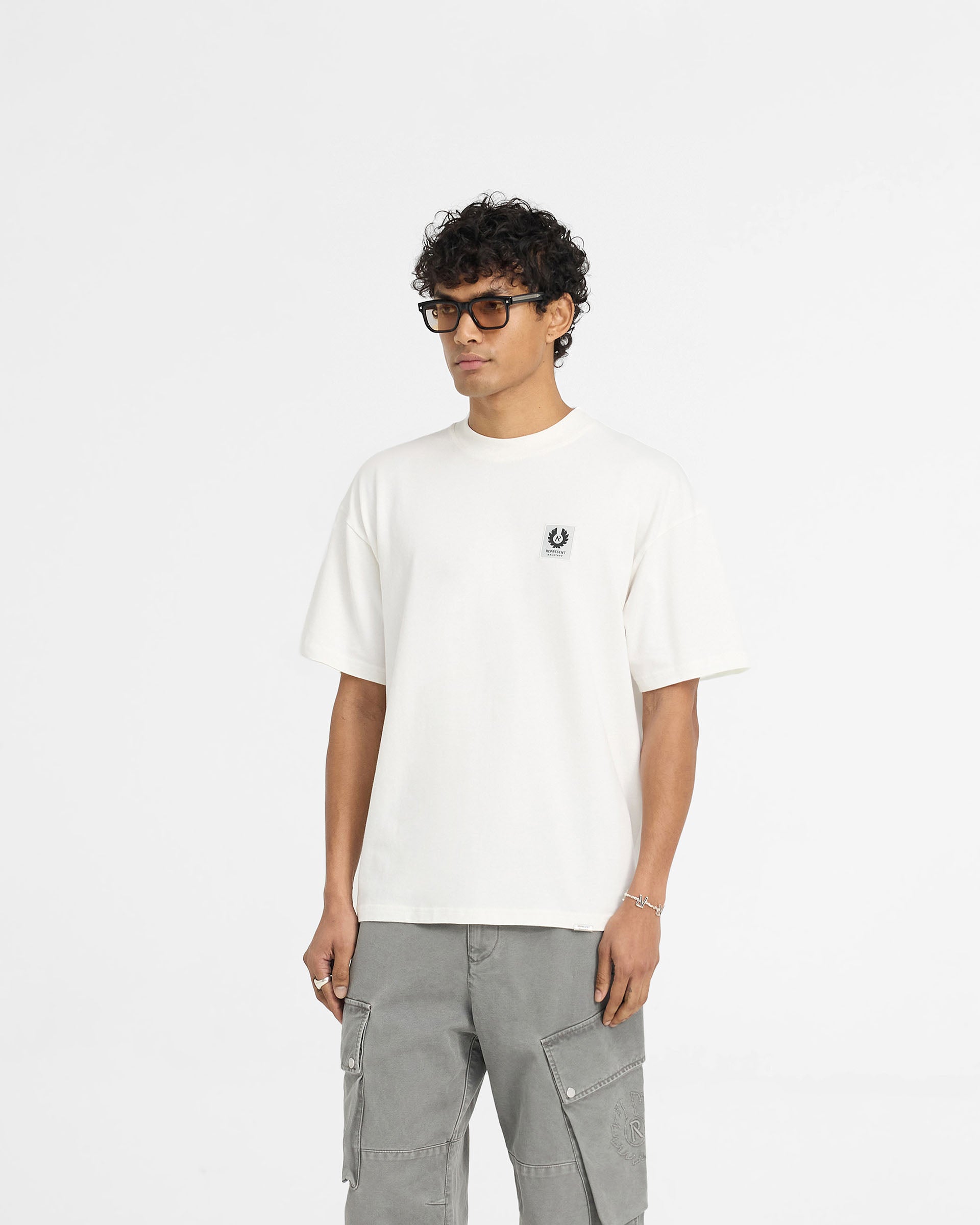 Back product image of a mens white t-shirt on a plain white background | Represent X Belstaff Patch T-Shirt in Flat White | T-Shirt with woven patch branding | Exclusives T-Shirts | Represent Clo