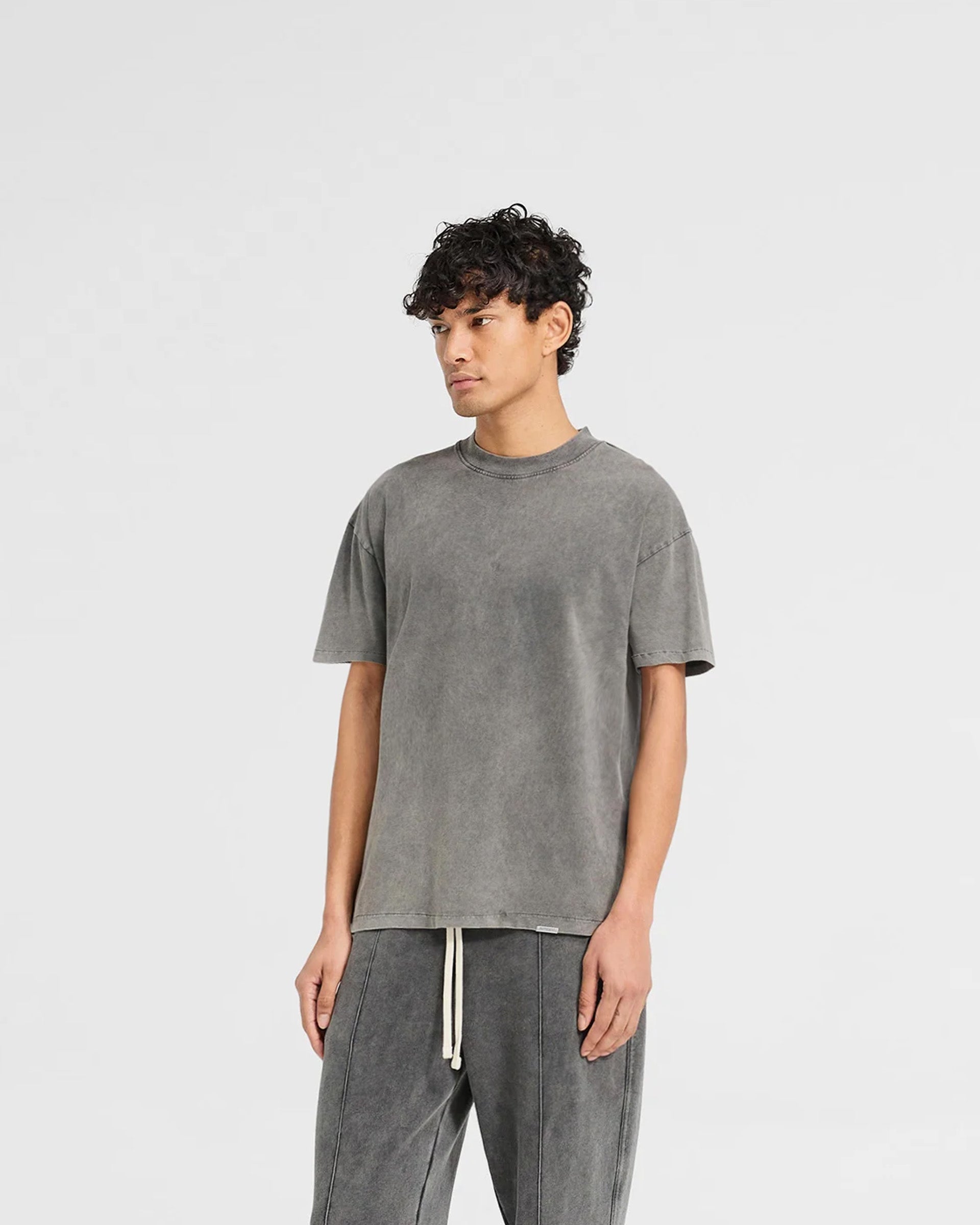 Man wearing a grey t-shirt on a plain white background | Initial T-Shirt in Vintage Grey | Regular fit t-shirt with ribbed collar and embroidered details | Initial T-Shirts | Represent Clo