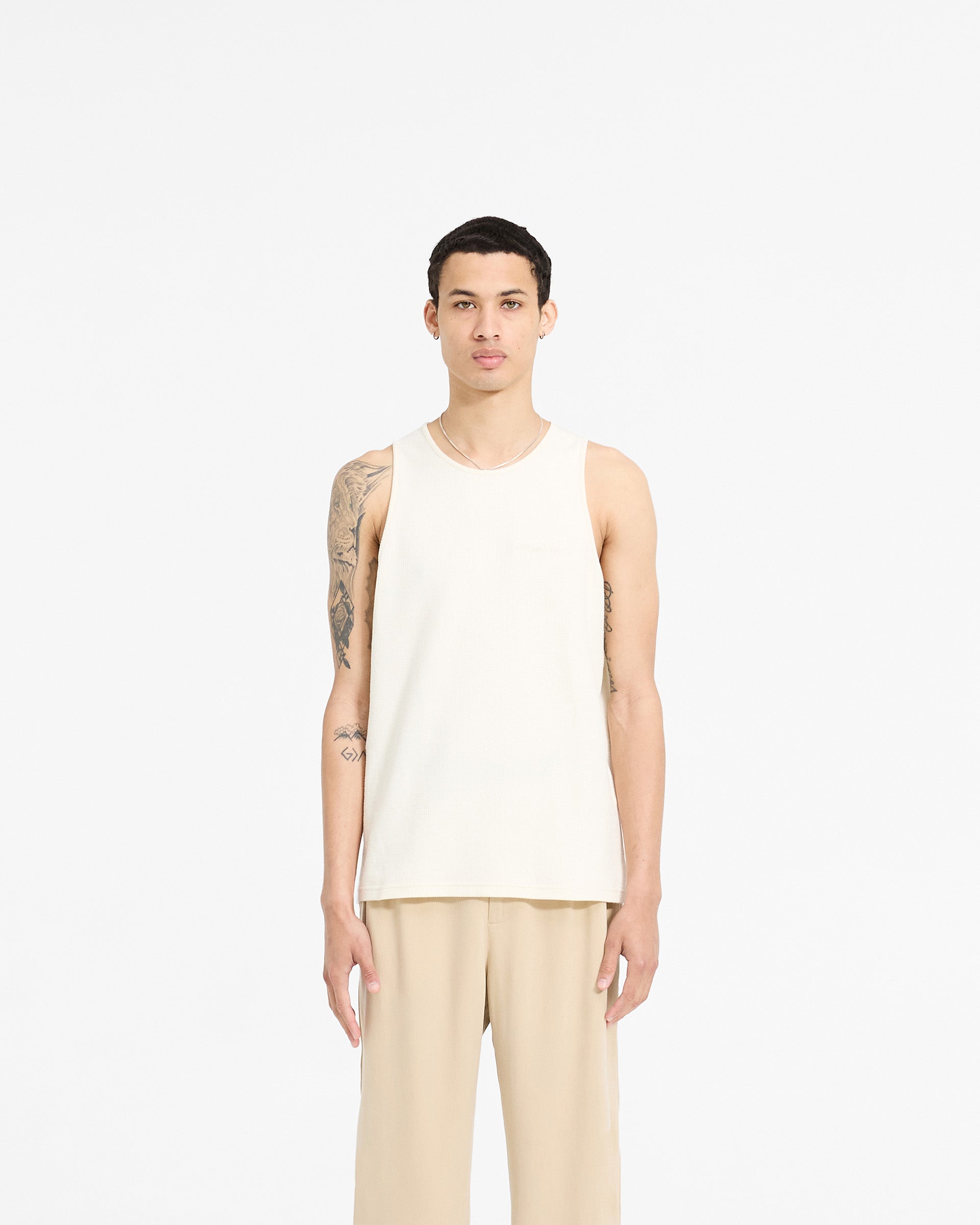 Man wearing an antique white vest on a plain white background | Waffle Vest in Antique White | Regular fit waffle jersey vest with embroidery | SC24 T-Shirts | Represent Clo