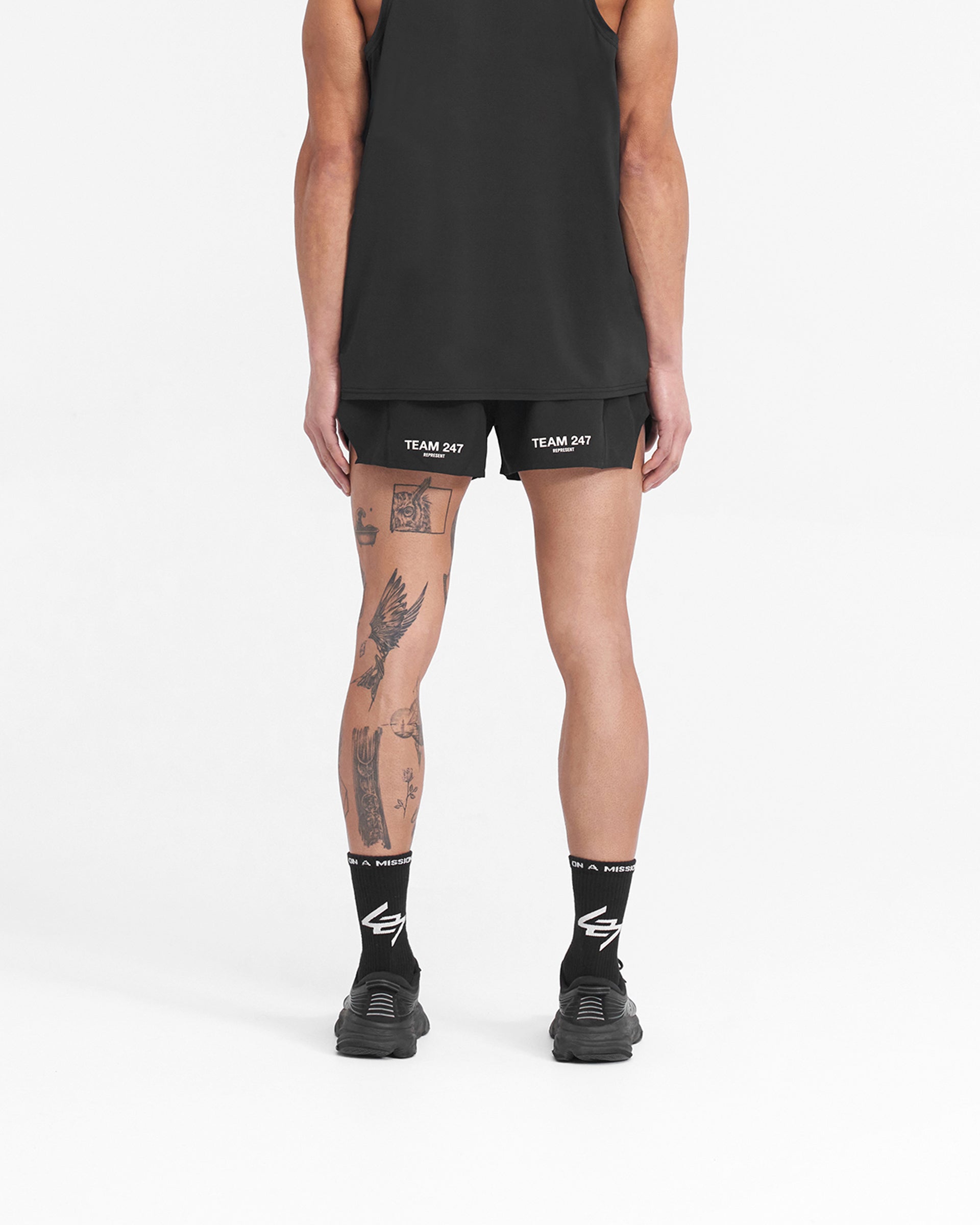 Man wearing black race shorts on a plain white background | Team 247 Race Shorts in Jet Black | Shorts with large side split and zip pocket | 247 Shorts | Represent Clo