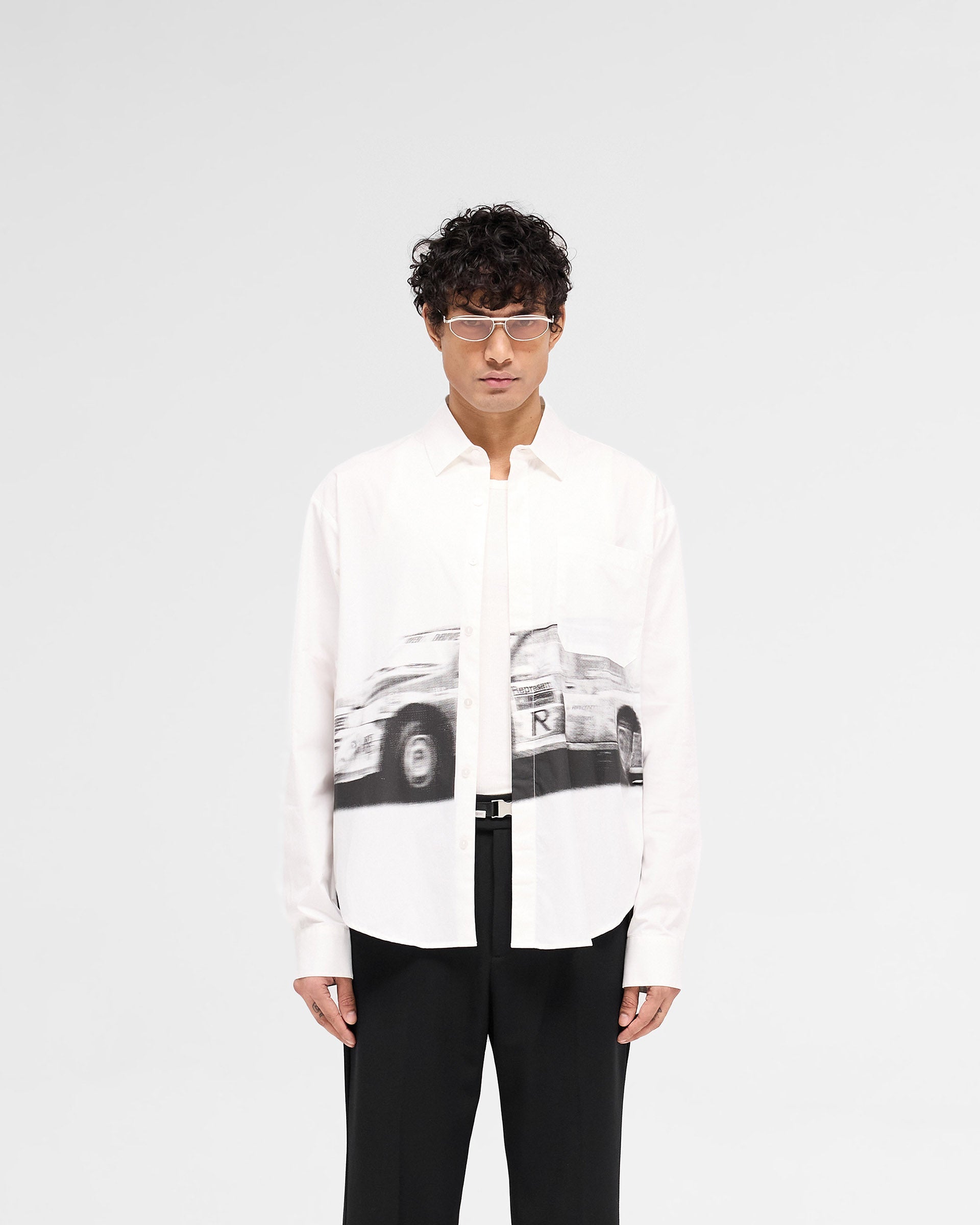 Man wearing a slightly oversized off white shirt on a plain white background | Raceway Shirt in Off White | Shirt with Raceway artwork and concealed button placket | SS25 Shirts | Represent Clo