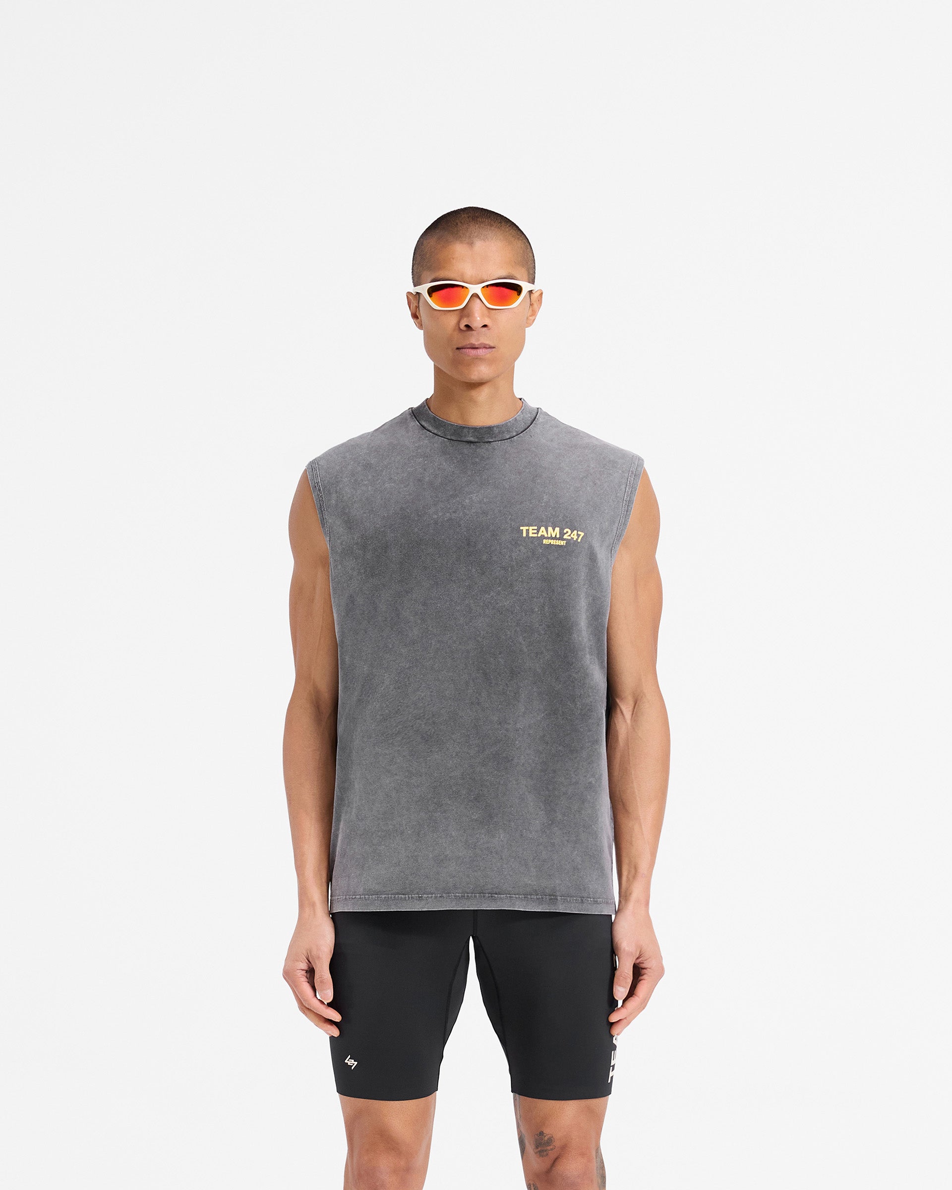 Man wearing an oversized grey tank top with yellow detailing on a plain white background | Team 247 Oversized Tank in Pewter Lemon | Oversized tank top with breathable quick-drying fabric | 247 T-Shirts | Represent Clo