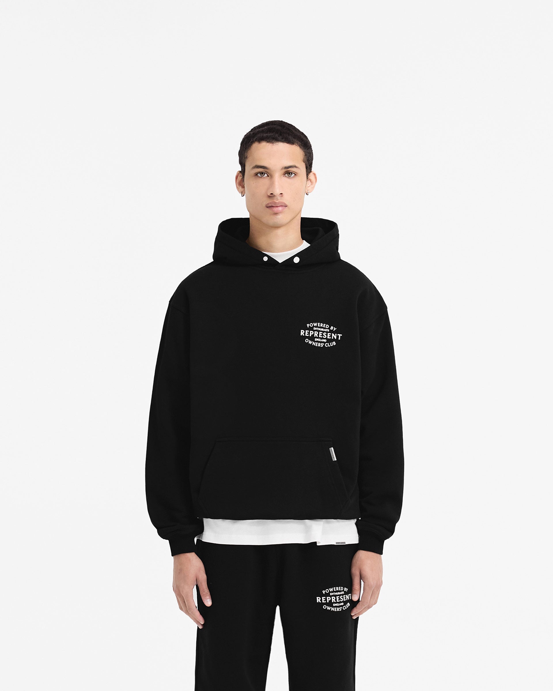 Man wearing a black hoodie on a plain white background | Represent Owners Club Stamp Hoodie in Jet Black | Oversized fit hoodie with high build branding | Owners Club Hoodies | Represent Clo