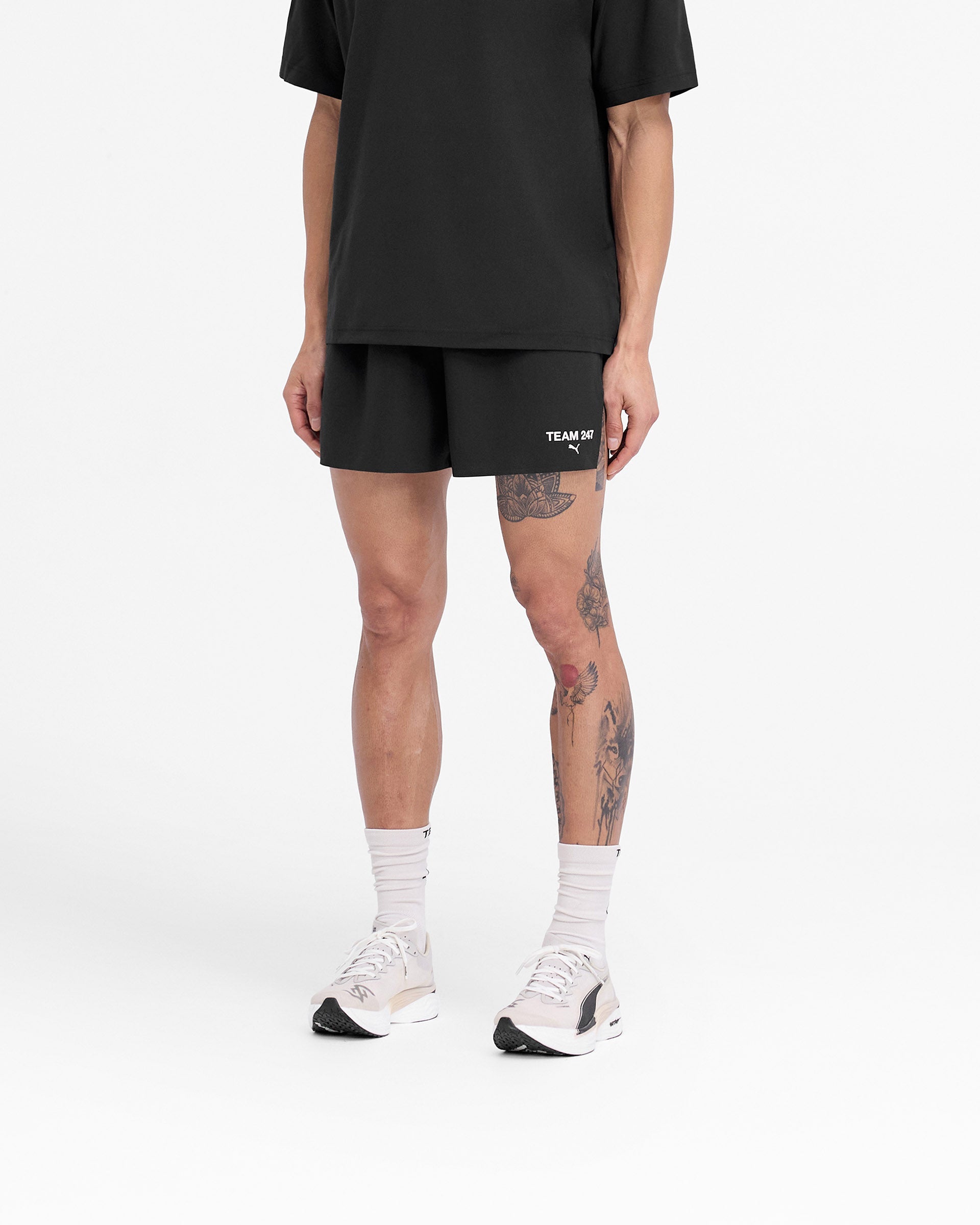 Man wearing black shorts on a plain white background | 247 X Puma Shorts in Black | Lightweight shorts with bonded seams and mesh waistband | 247 Shorts | Represent Clo