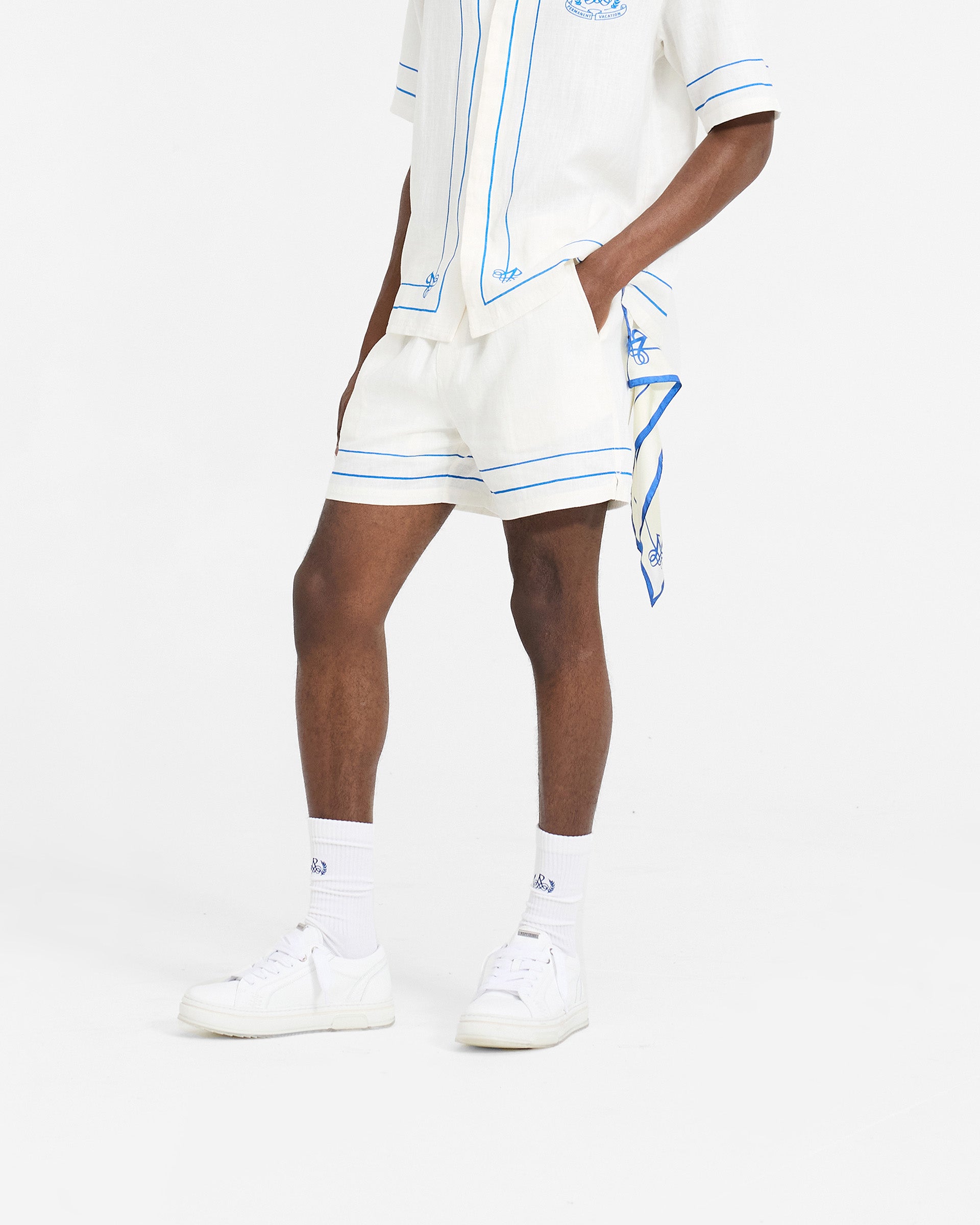 Man wearing white shorts on a plain white background | Permanent Vacation Short in Flat White | Relaxed fit shorts with elasticated waistband | SC24 Shorts | Represent Clo