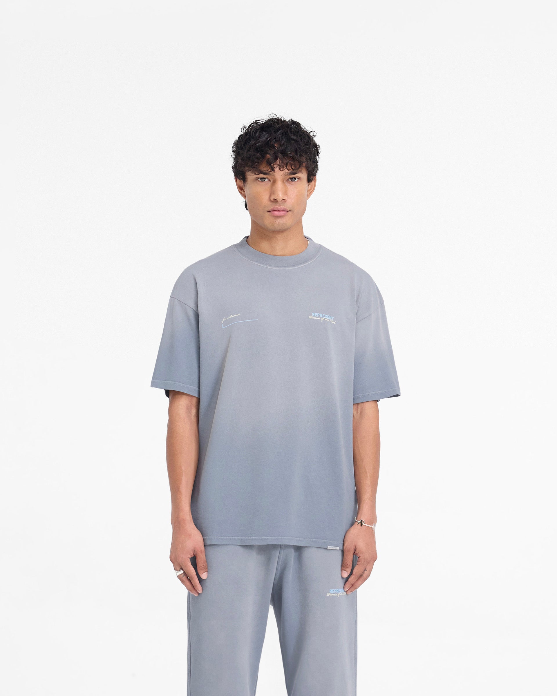 Man wearing a grey t-shirt on a plain white background | Patron Of The Club T-Shirt in Washed Grey | Slightly oversized fit t-shirt with fade out wash | Patrons T-Shirts | Represent Clo
