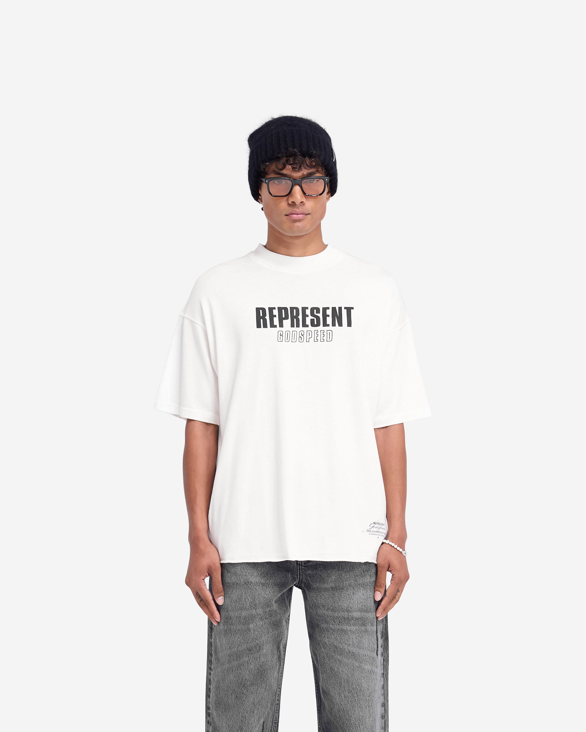 Man wearing a white t-shirt on a plain white background | Godspeed T-Shirt in Flat White | Oversized t-shirt with raw hem and cracked graphics | FW24 T-Shirts | Represent Clo