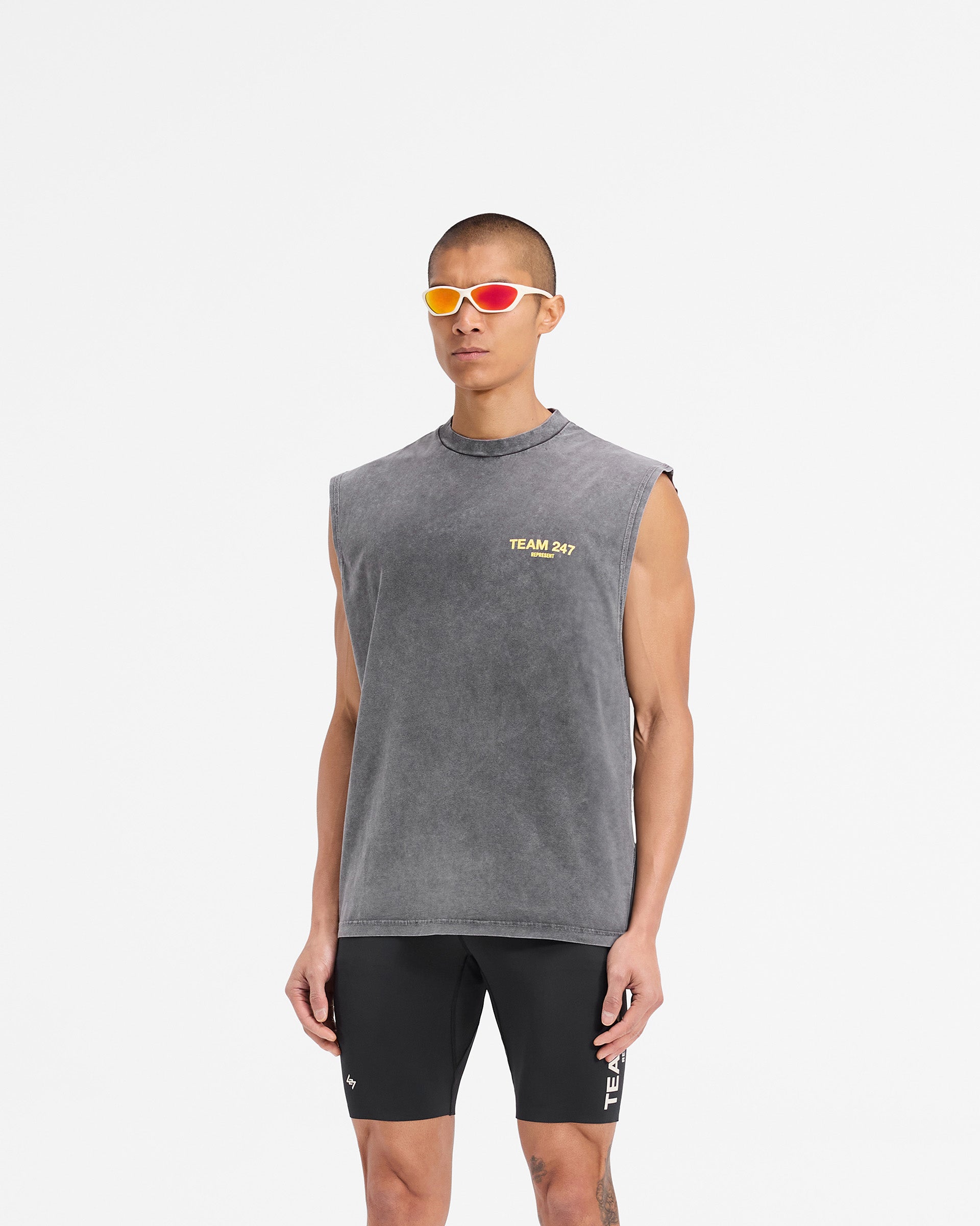 Man wearing an oversized grey and yellow tank top on a plain white background | Team 247 Oversized Tank in Pewter Lemon | Quick drying tank with Team 247 branding | 247 T-Shirts | Represent Clo