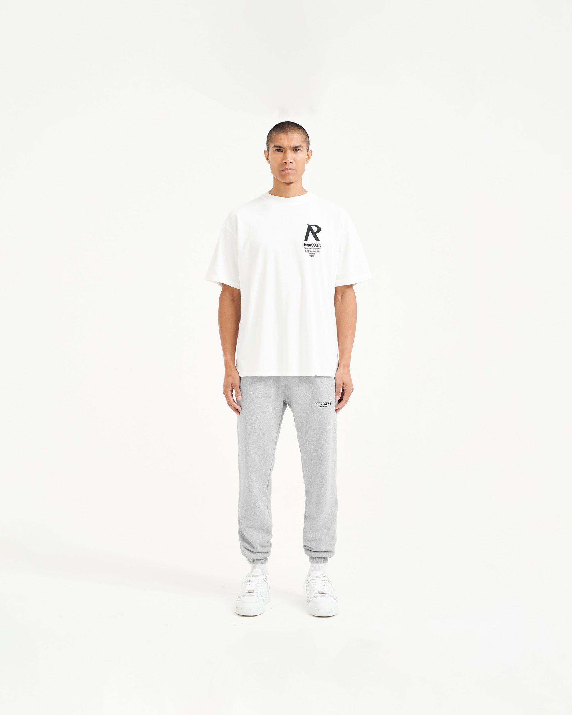 Man wearing grey sweatpants on a plain white background | Represent Owners Club Sweatpant in Ash Grey | Sweatpants with elasticated waistband and cuffs | Owners Club Pants | Represent Clo