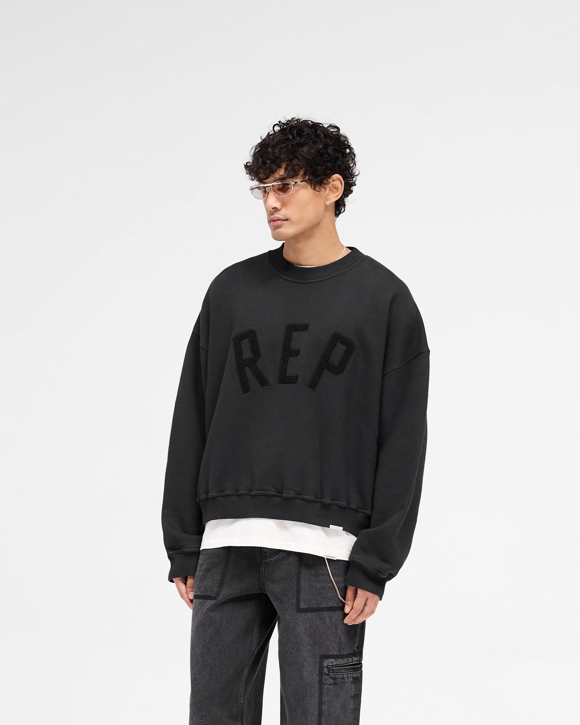 Back product image of a mens black sweater on a plain white background | Rep Applique Sweater in Off Black | Sweater with textured Rep applique | SS25 Sweaters | Represent Clo