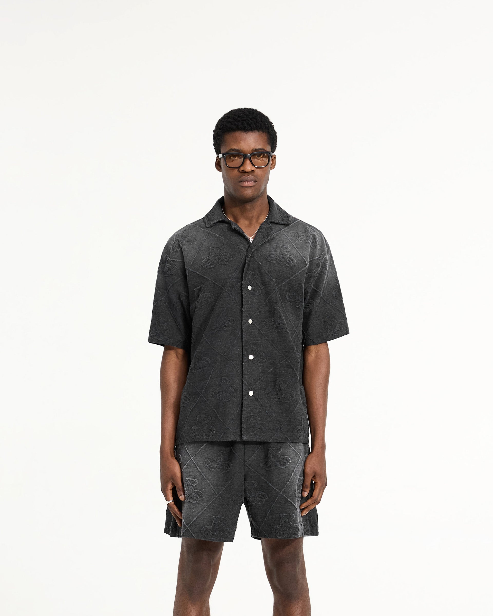 Man wearing a black towelling shirt on a plain white background | Towelling Shirt in Jet Black | Oversized fit shirt with popper fastenings | SC24 Shirts | Represent Clo