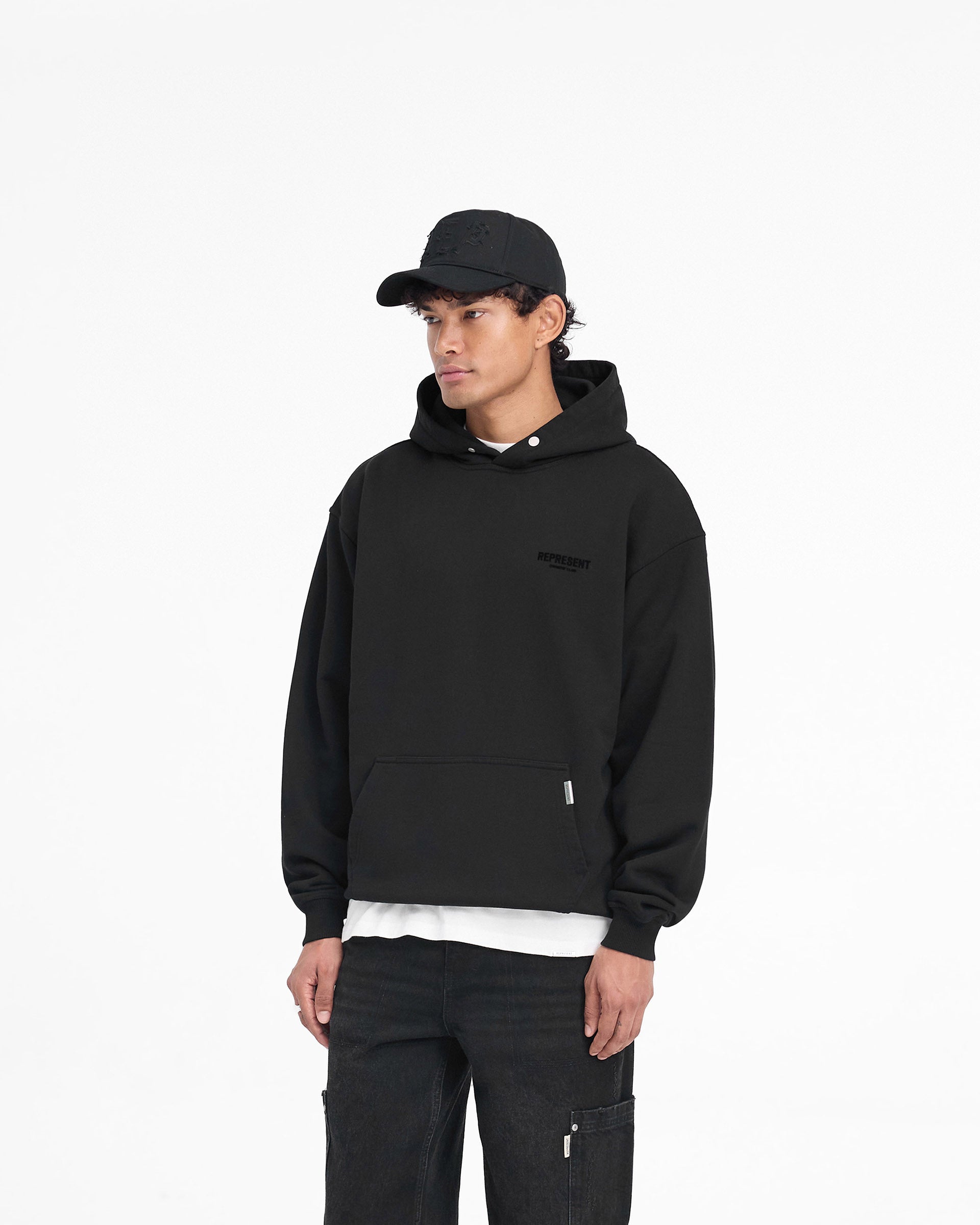 Man wearing a black hoodie on a plain white background | Represent Owners Club Flocked Hoodie in Black | Oversized hoodie with flocking print | Owners Club Hoodies | Represent Clo